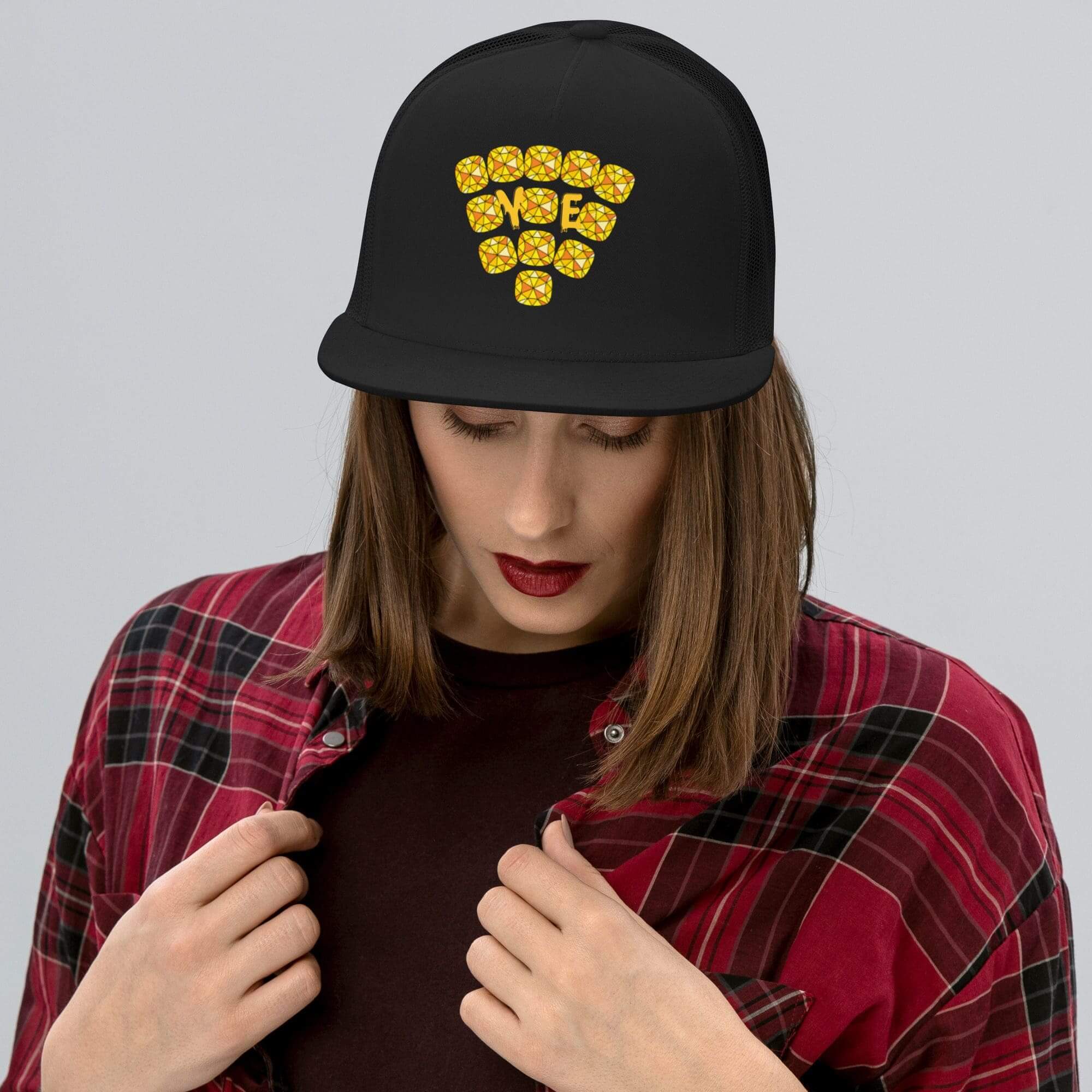 Woman wearing black cap with yellow design.