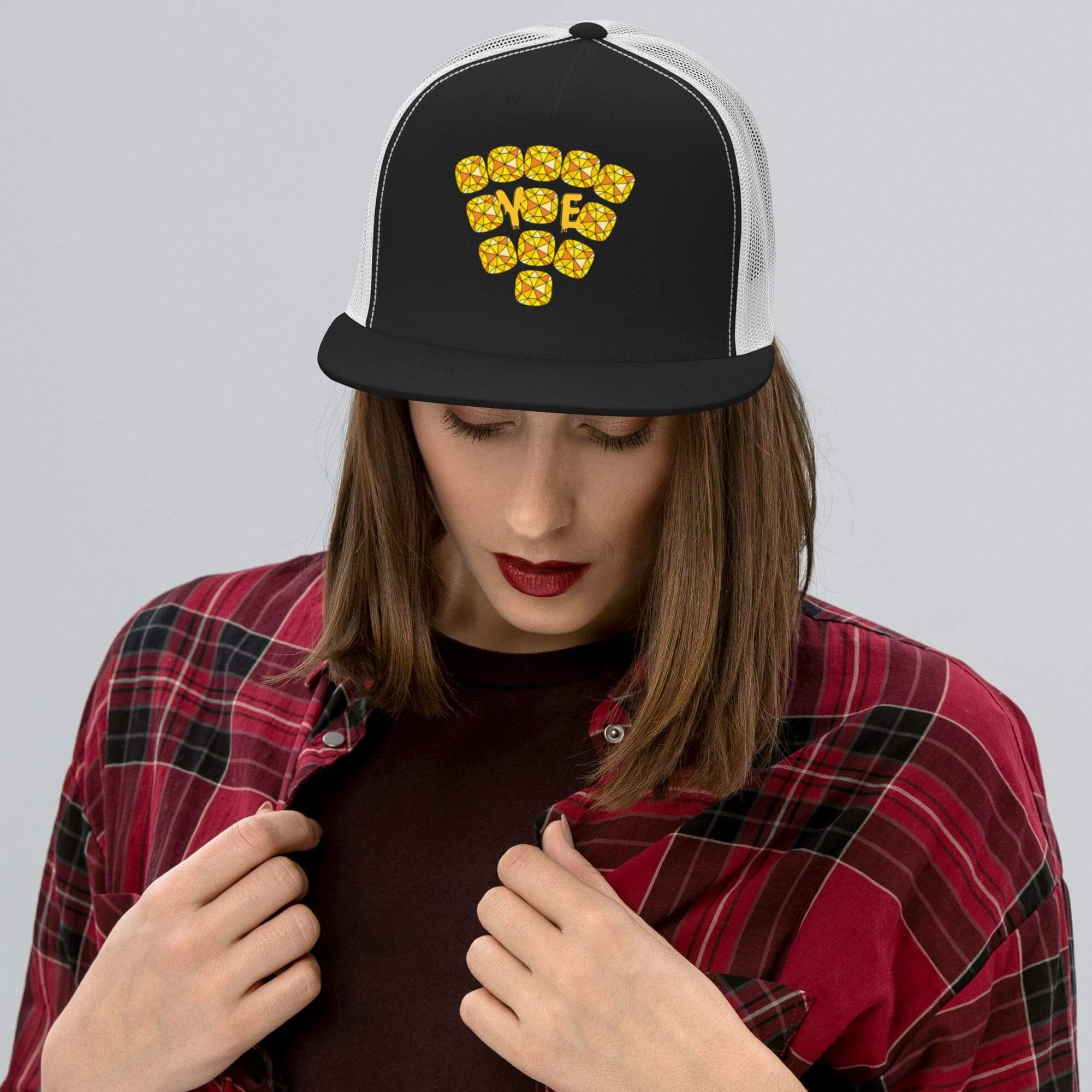 Person wearing embroidered cap and plaid shirt.