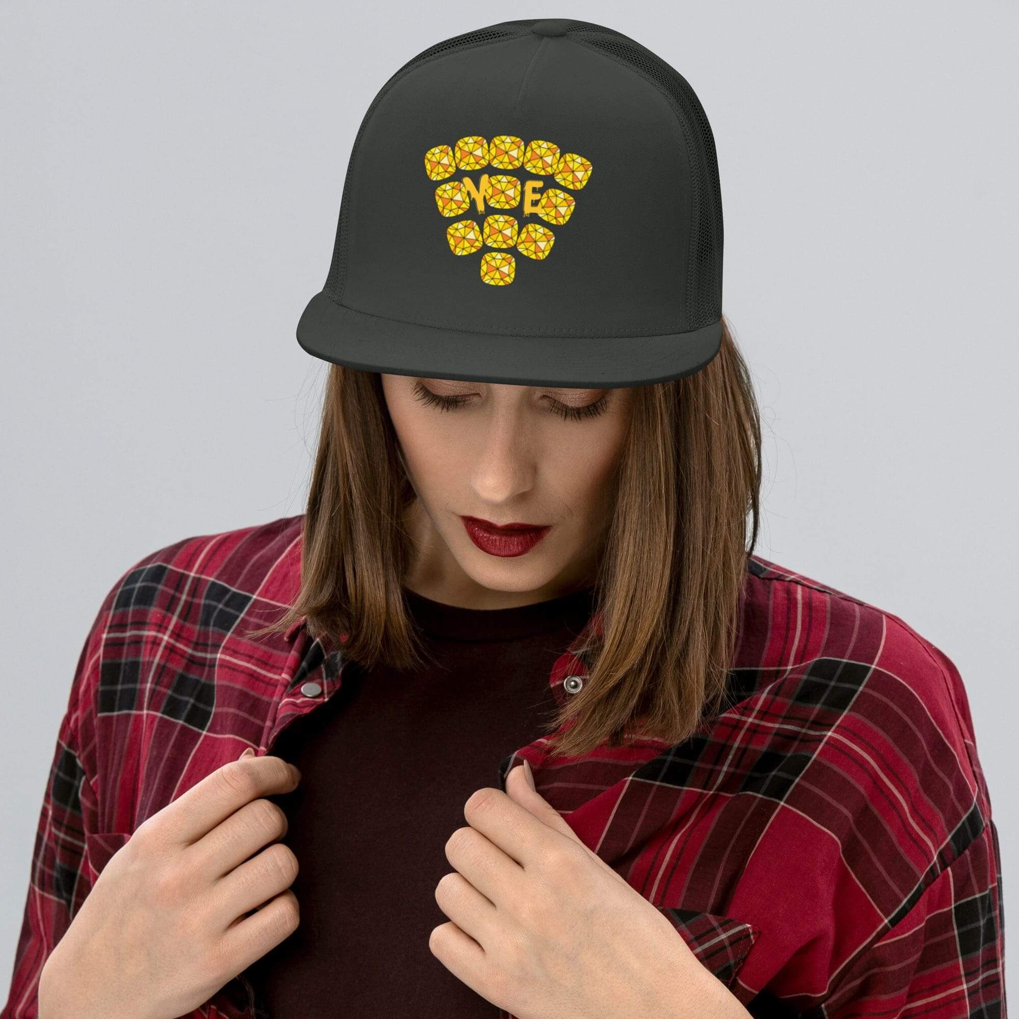 Woman wearing black cap and plaid shirt.