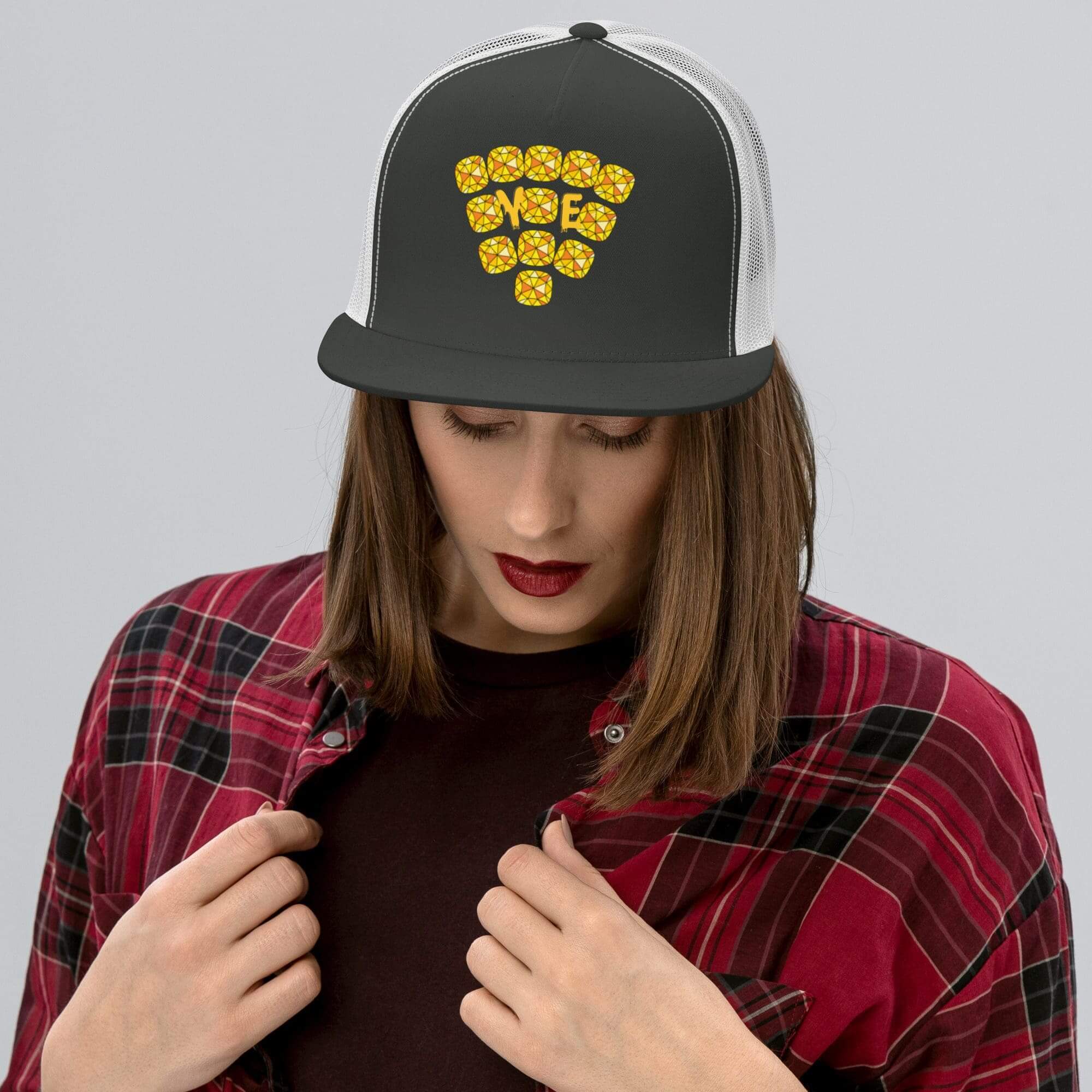 Woman wearing checkered shirt and black cap.