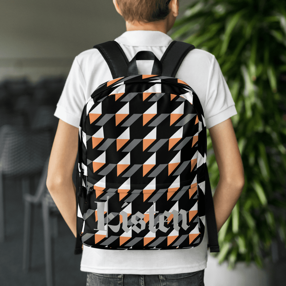 Person wearing geometric patterned backpack indoors.
