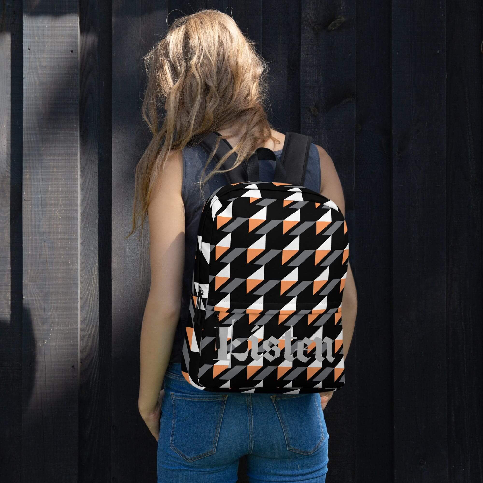Woman with geometric-patterned backpack, black background.