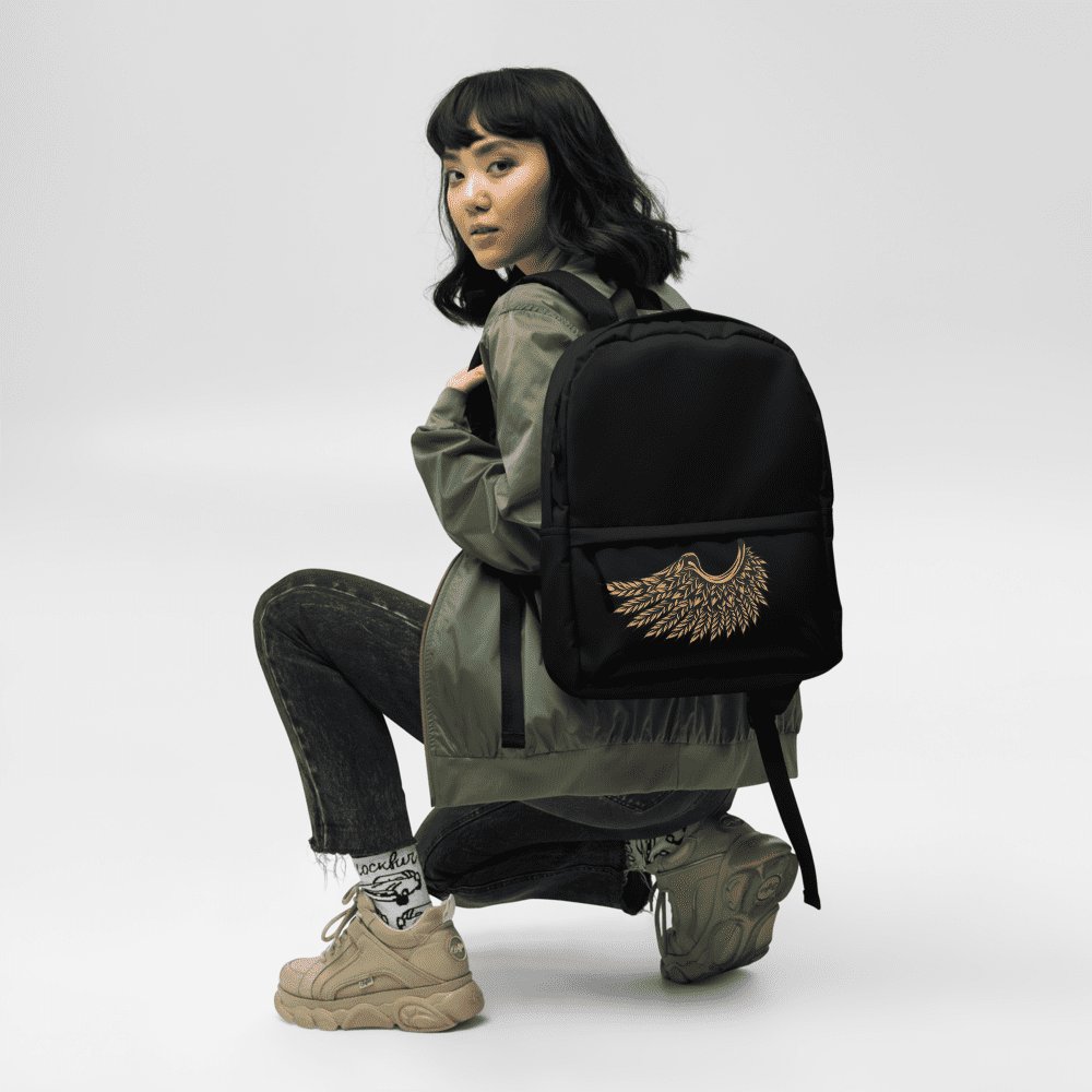 Person squatting with stylish black backpack.