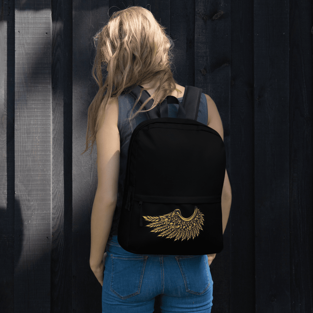 Woman with backpack standing against wooden wall.