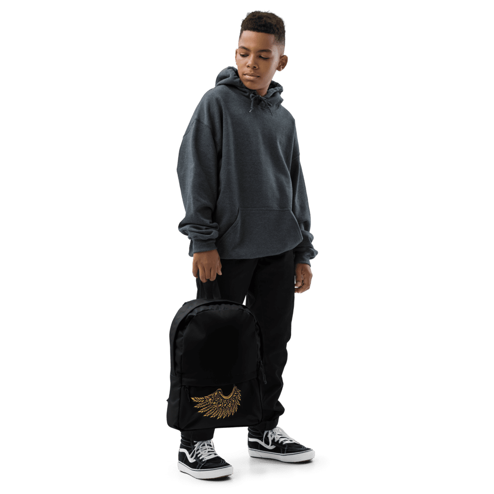 Teen in hoodie holding a black backpack.