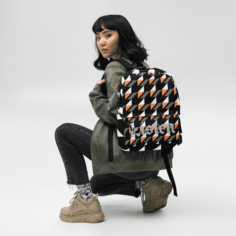 Person wearing geometric patterned backpack, crouching.