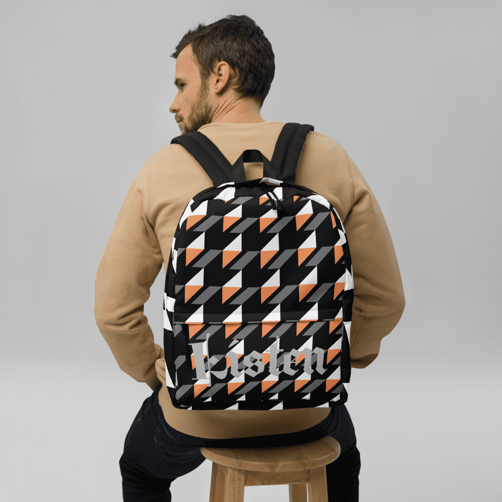 Man wearing geometric patterned backpack, sitting.