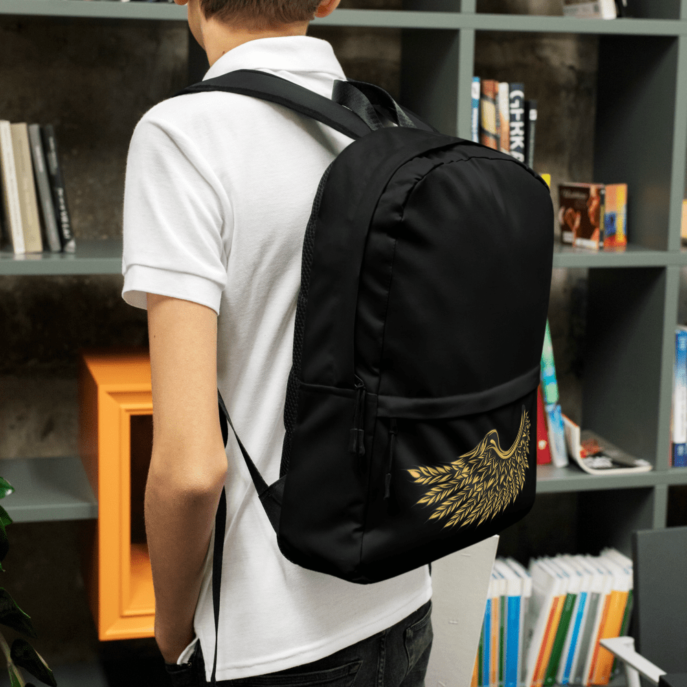 Person with backpack standing by bookshelves.