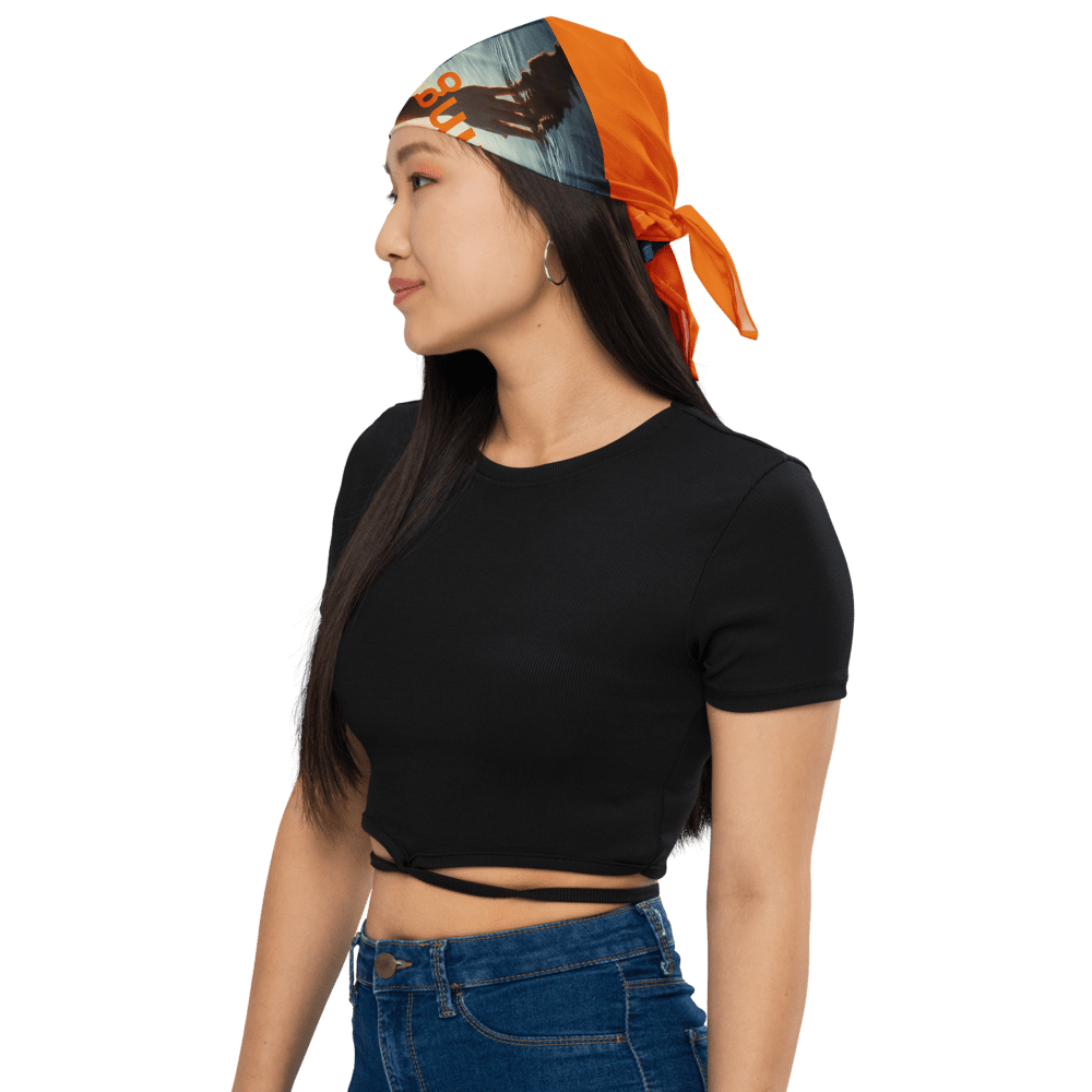 Woman wearing bandana and black top, side view.