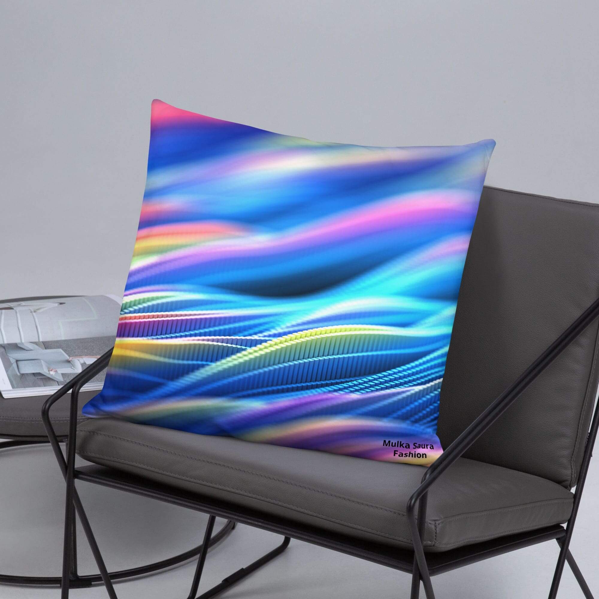 Colorful abstract pillow on gray chair.