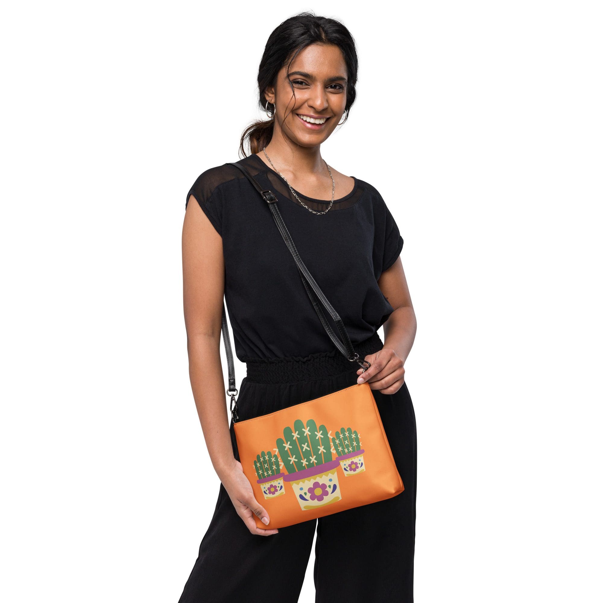 Woman holding orange bag with cactus design.