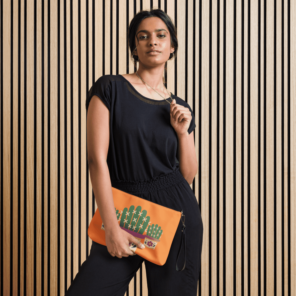 Woman wearing black, holding orange cactus clutch