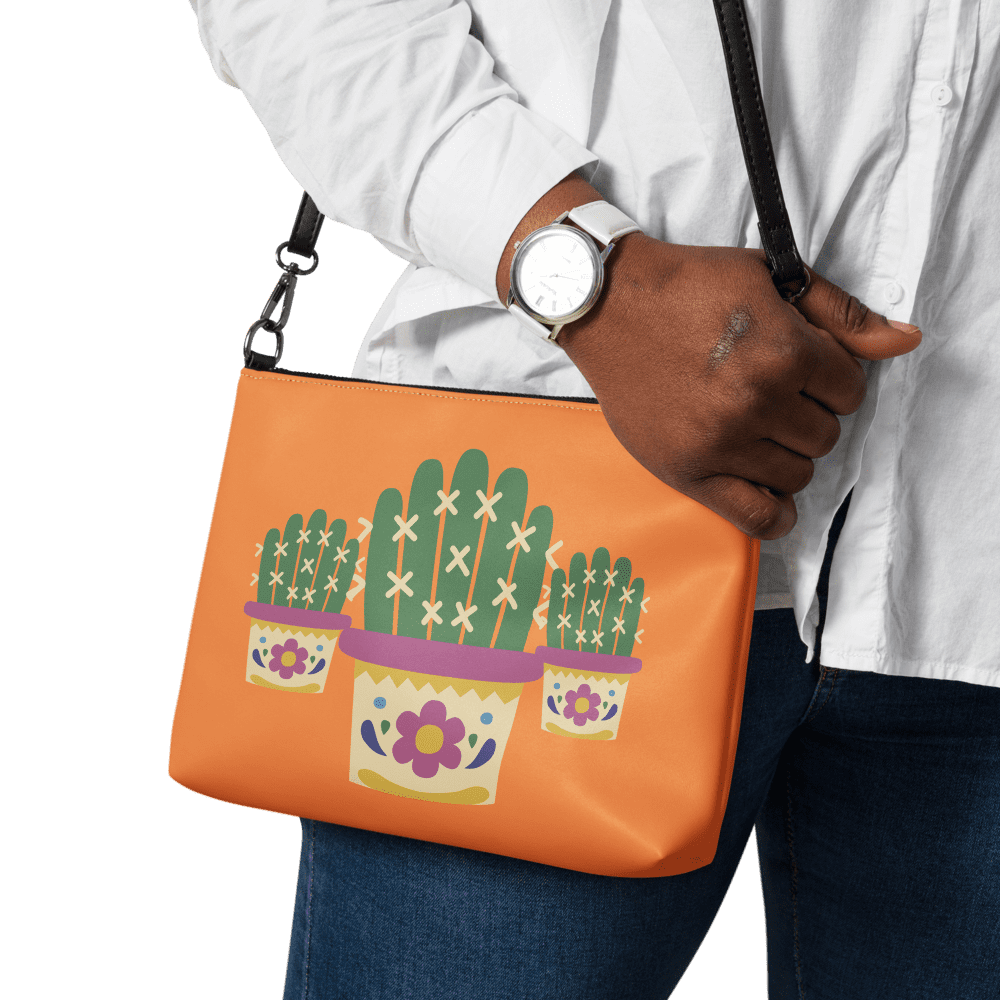 Person holding orange cactus-patterned bag.