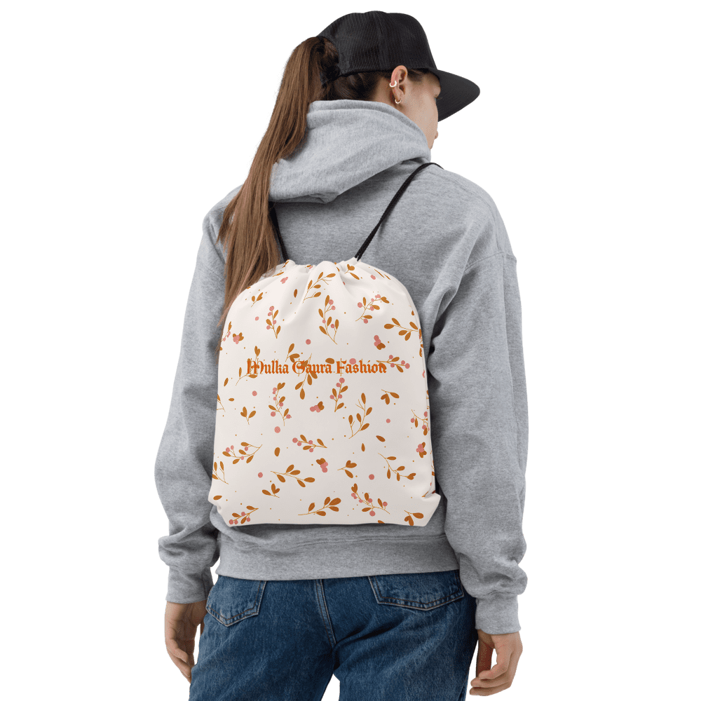 Person wearing floral drawstring bag, black background.