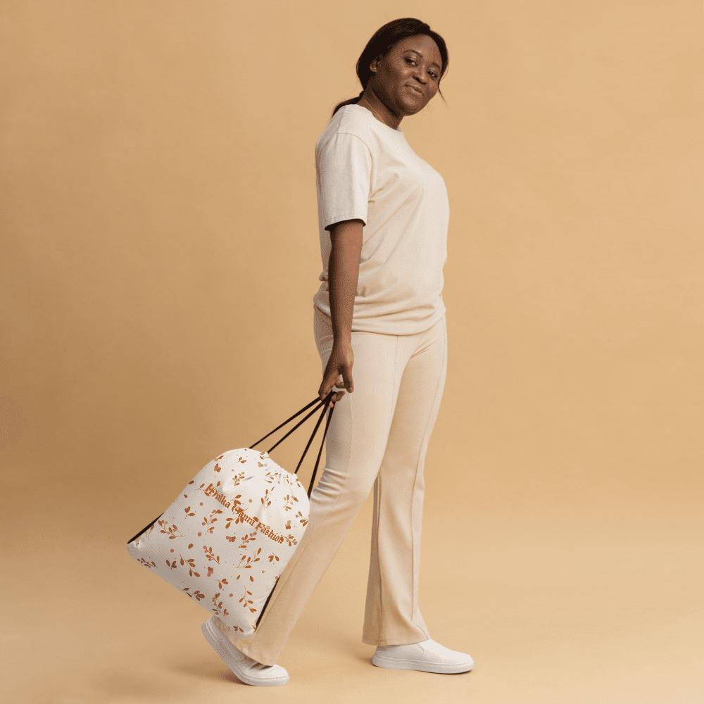 Person in beige outfit holding floral bag.