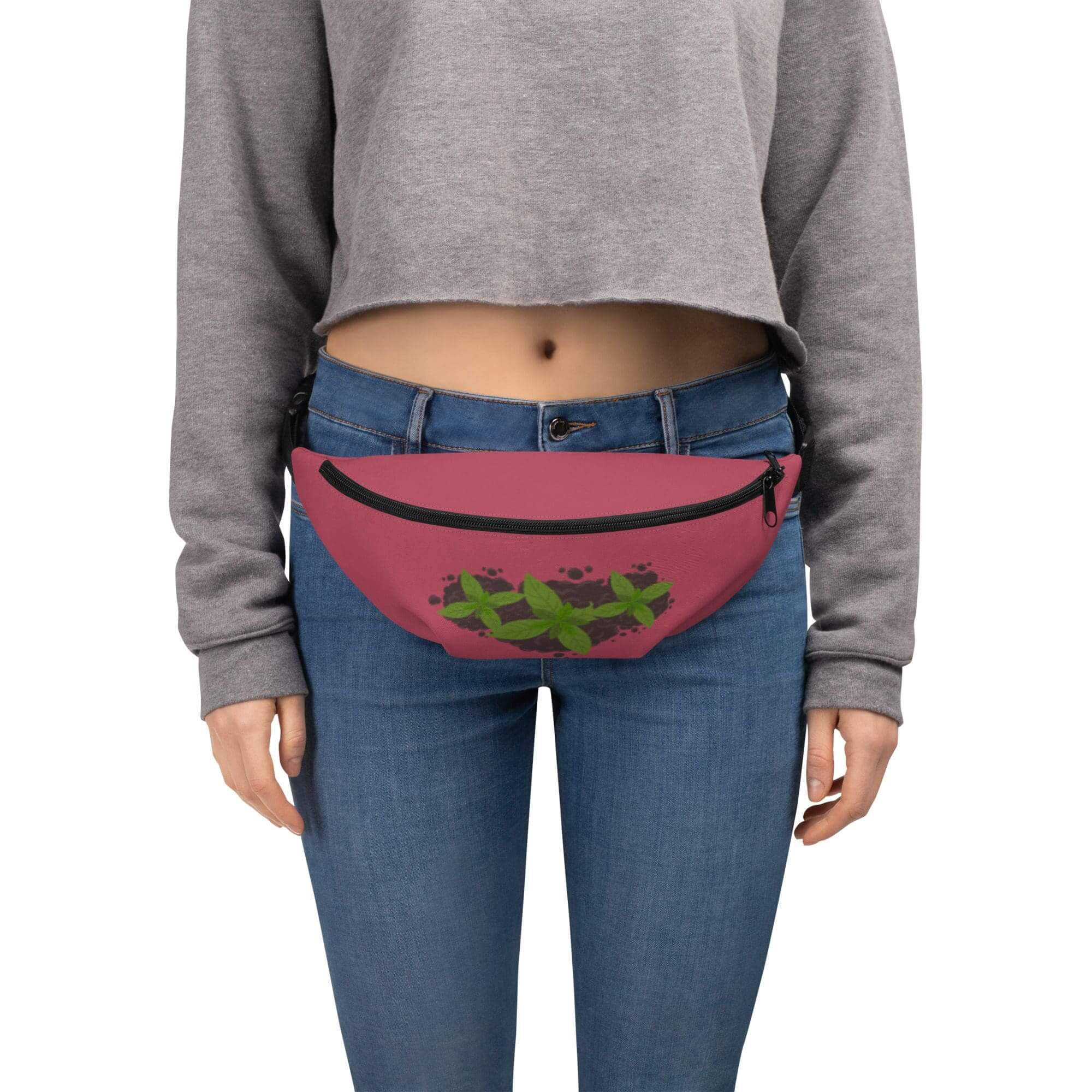Woman wearing pink waist bag, gray sweater.