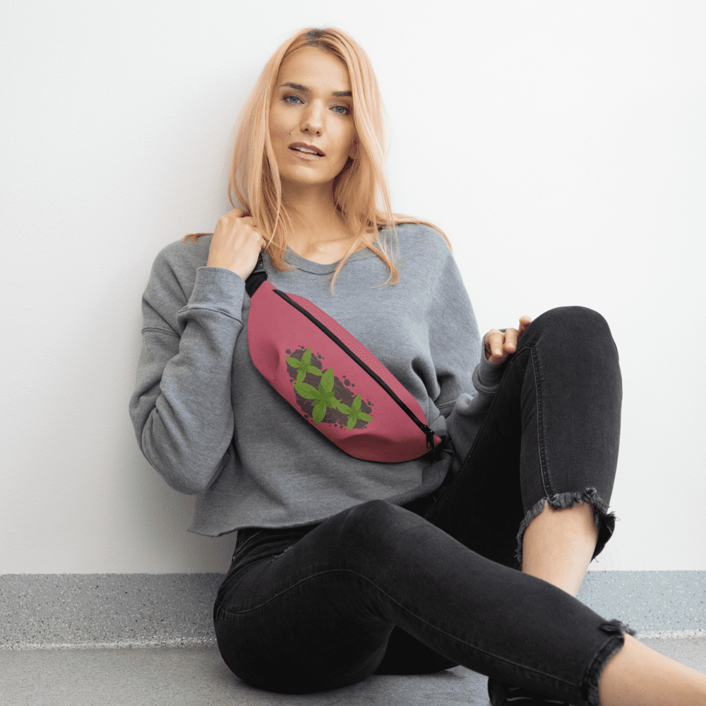 Woman sitting, wearing a pink fanny pack.