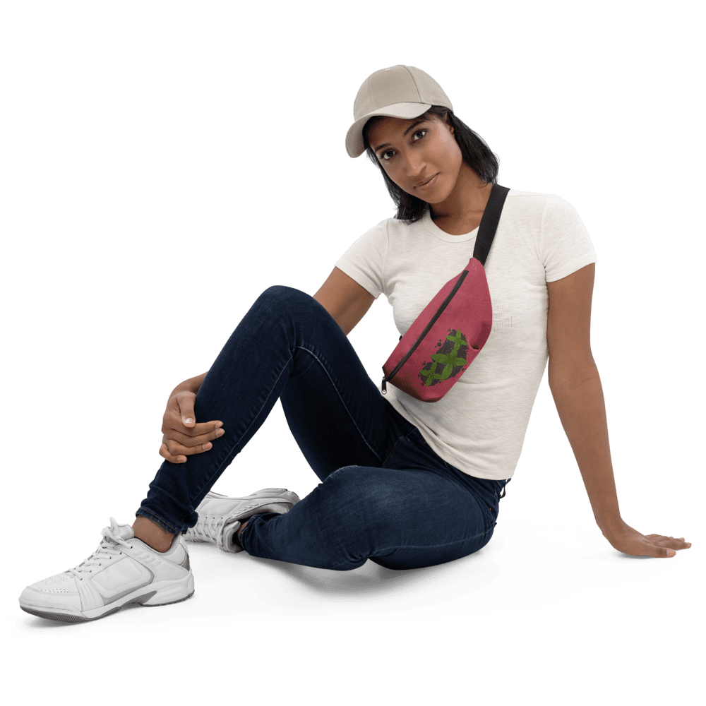 Woman sitting, wearing cap and fanny pack.