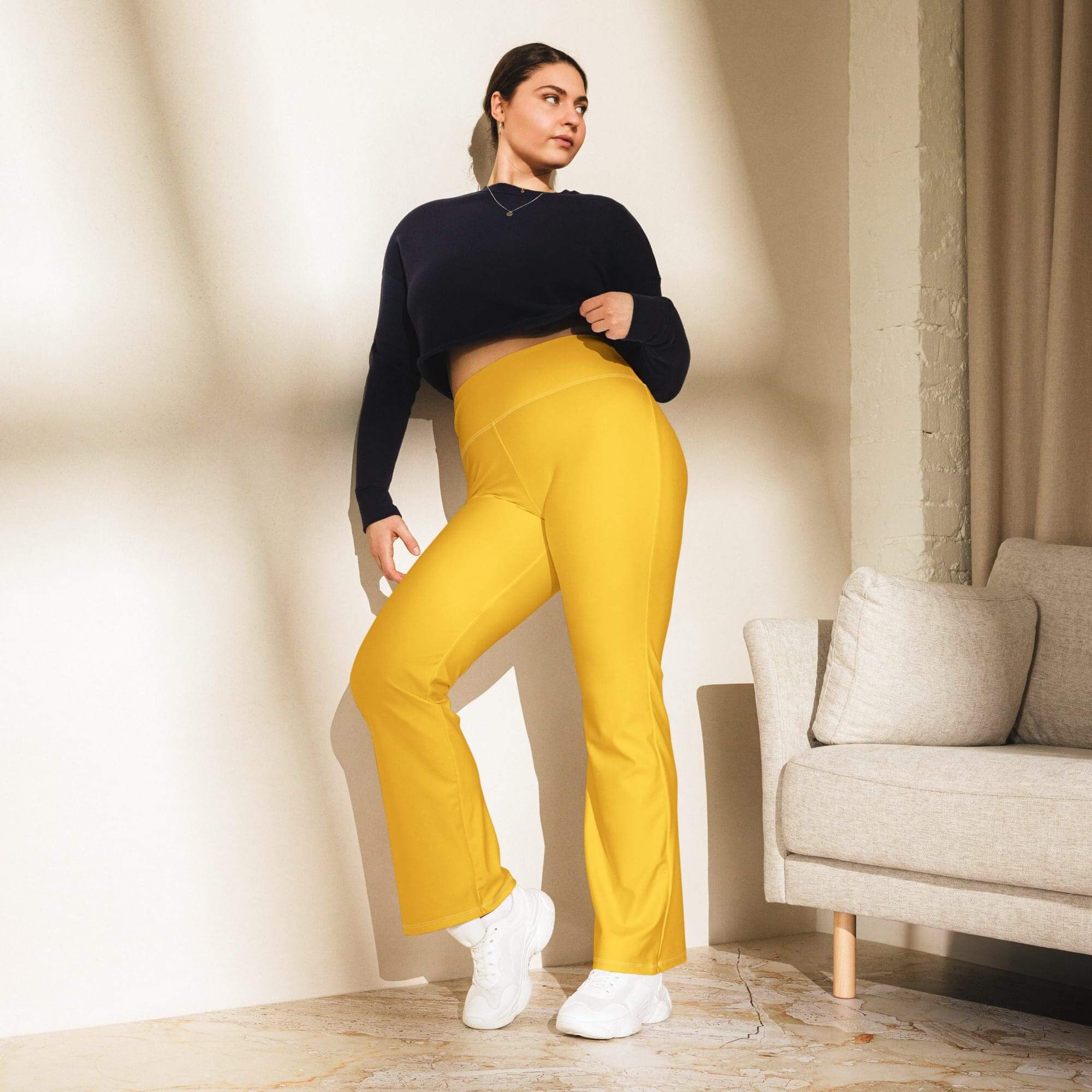 Woman posing in yellow pants indoors.