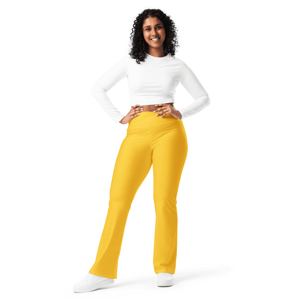 Smiling woman in yellow pants, black background.