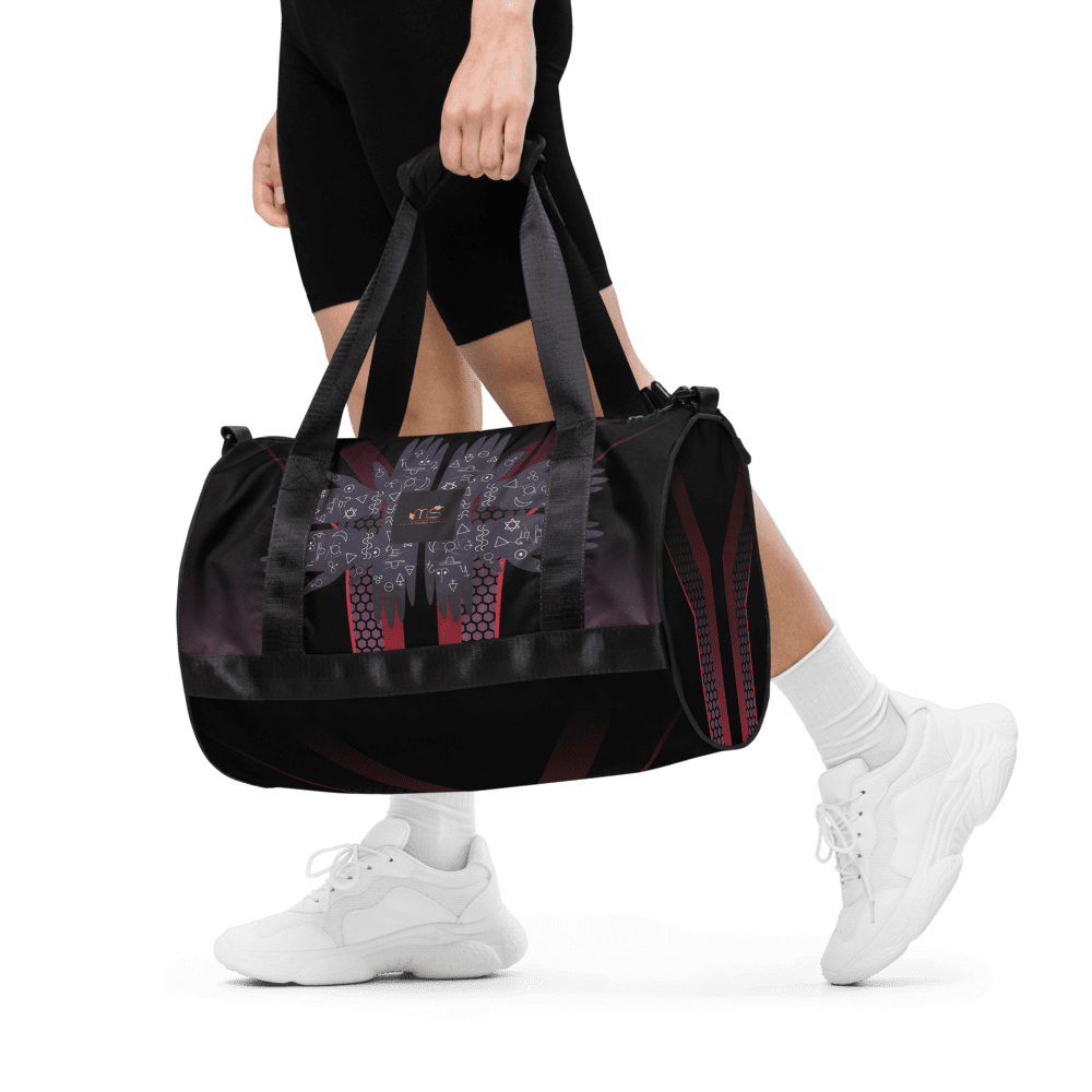 Person carrying black and red duffel bag.