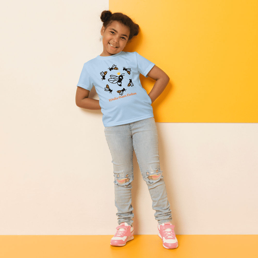 Girl posing in bee-themed shirt, smiling.