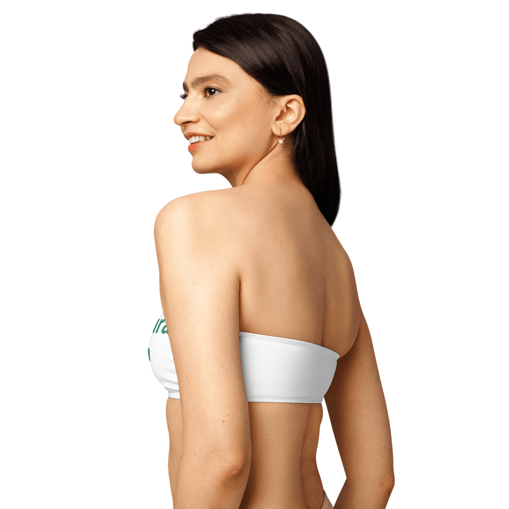 Woman smiling, wearing a white tube top.