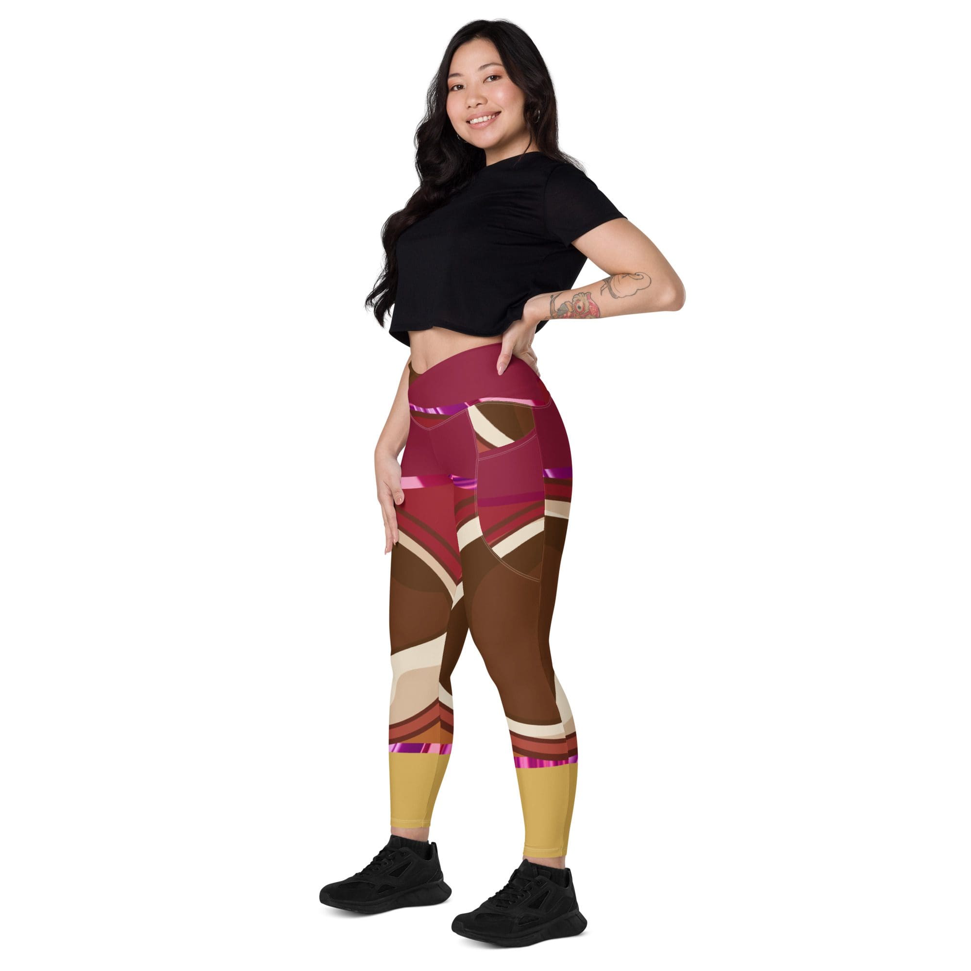Woman wearing colorful leggings, black top smiling.