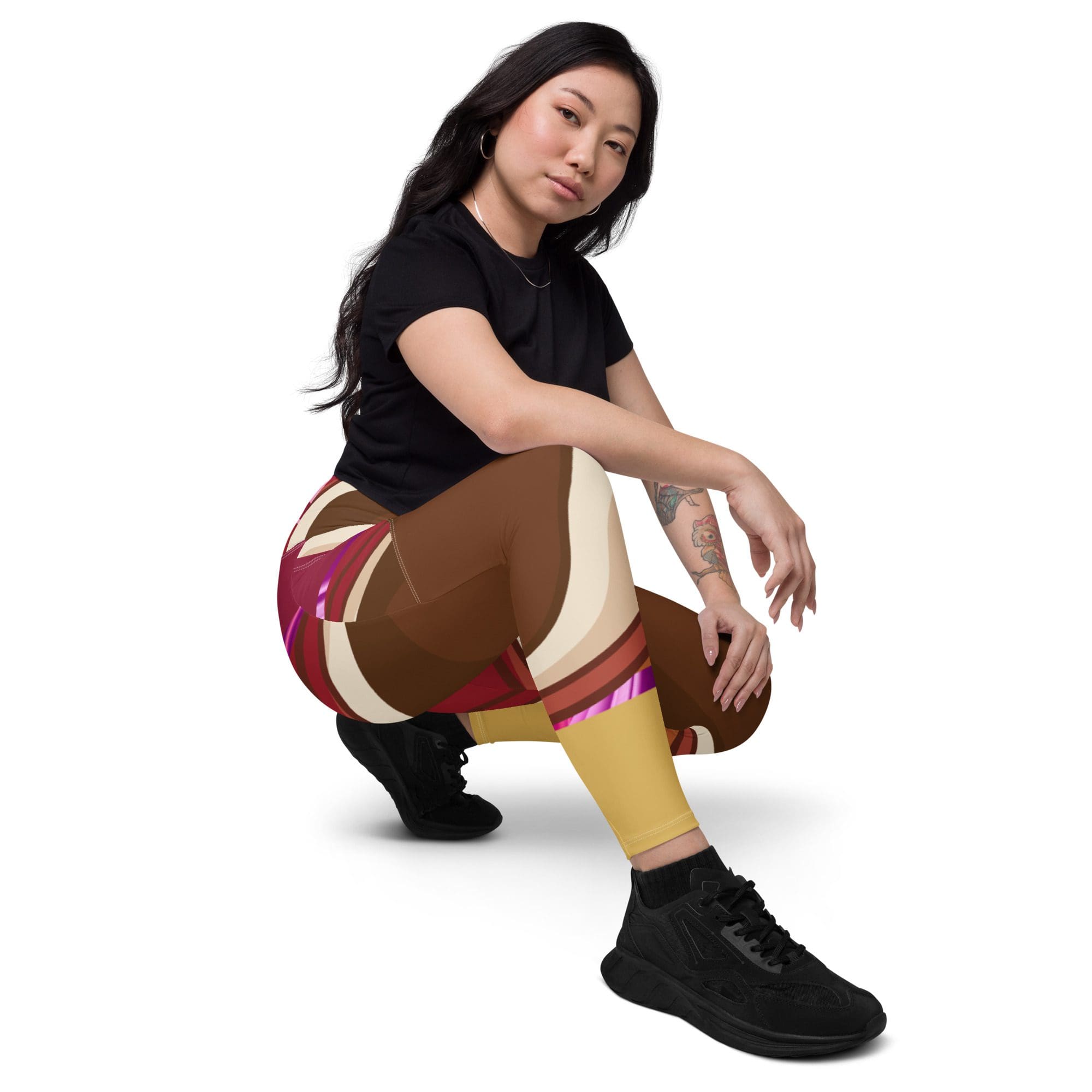 Woman posing in colorful leggings, squatting.