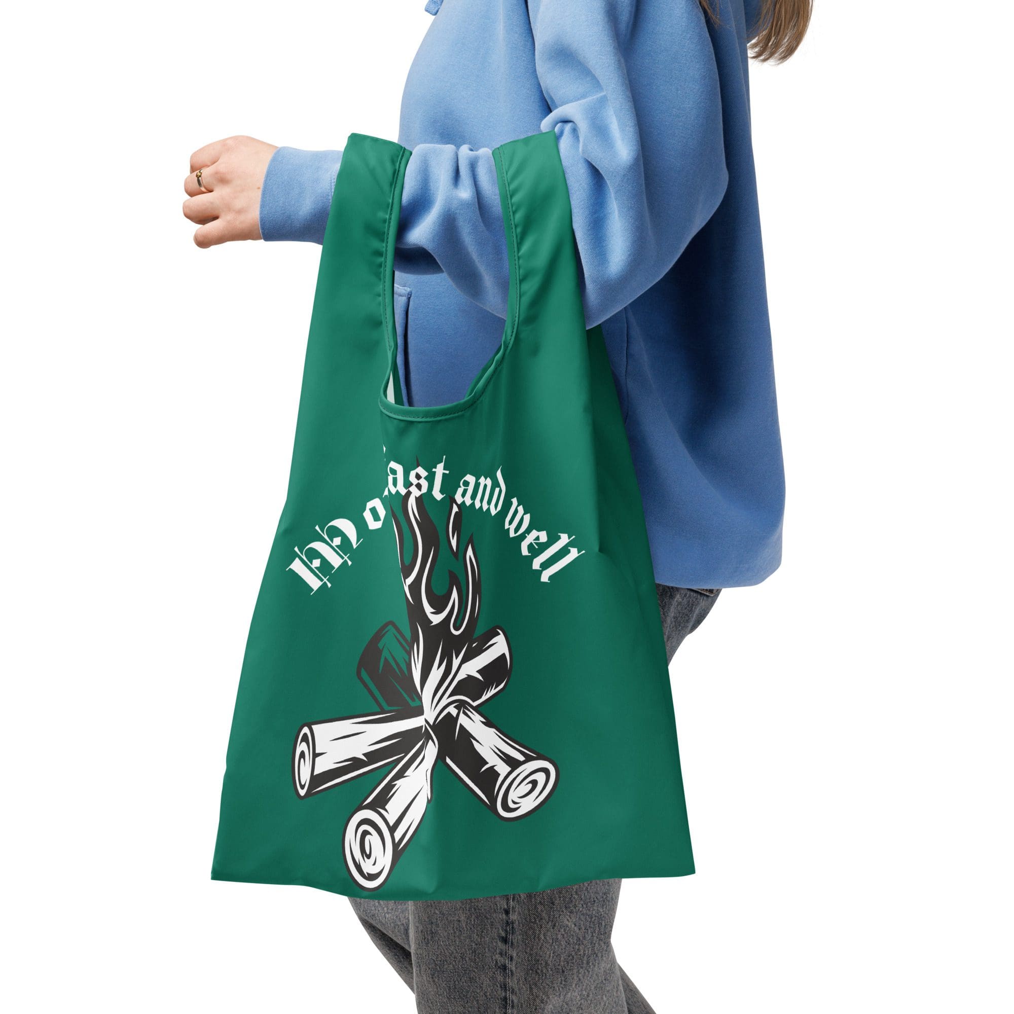 Person holding green tote bag with design.
