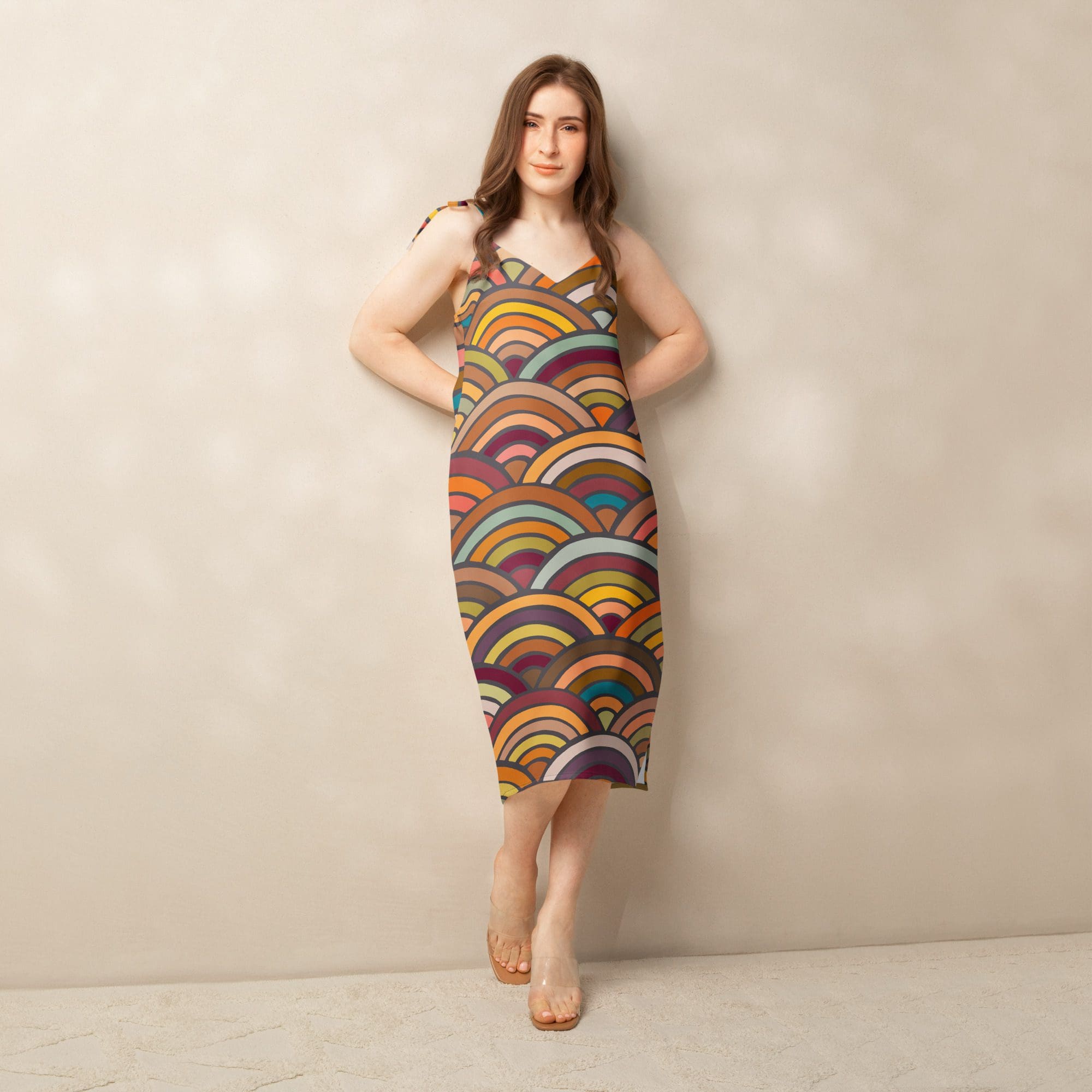 Woman in colorful patterned dress standing indoors.