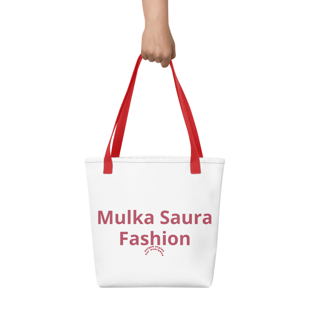 Hand holding white tote bag, red handles.