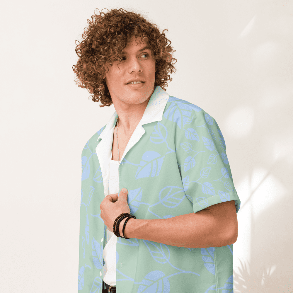 Man in patterned shirt, curly hair smiling.
