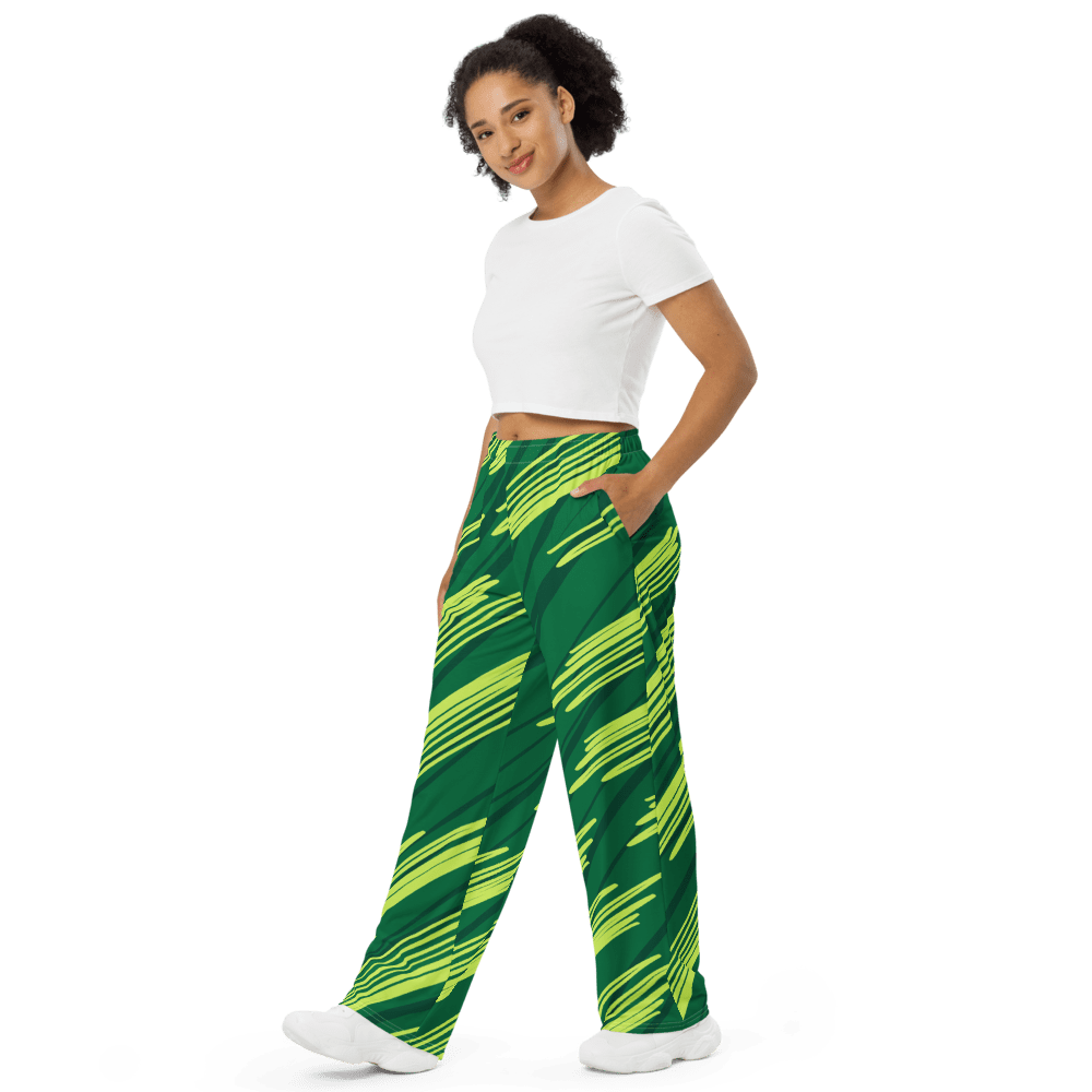 Woman wearing green patterned pants, black background.