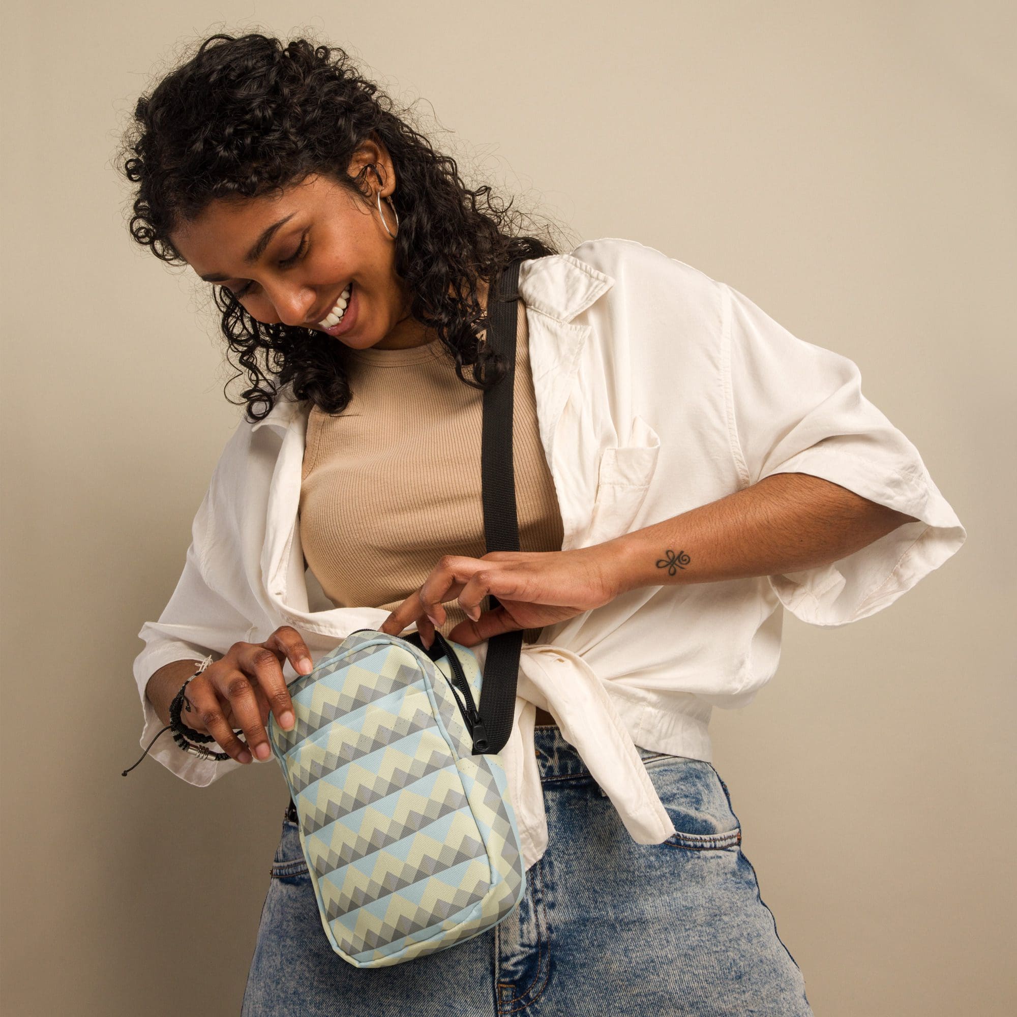 Woman smiling, holding a patterned bag.