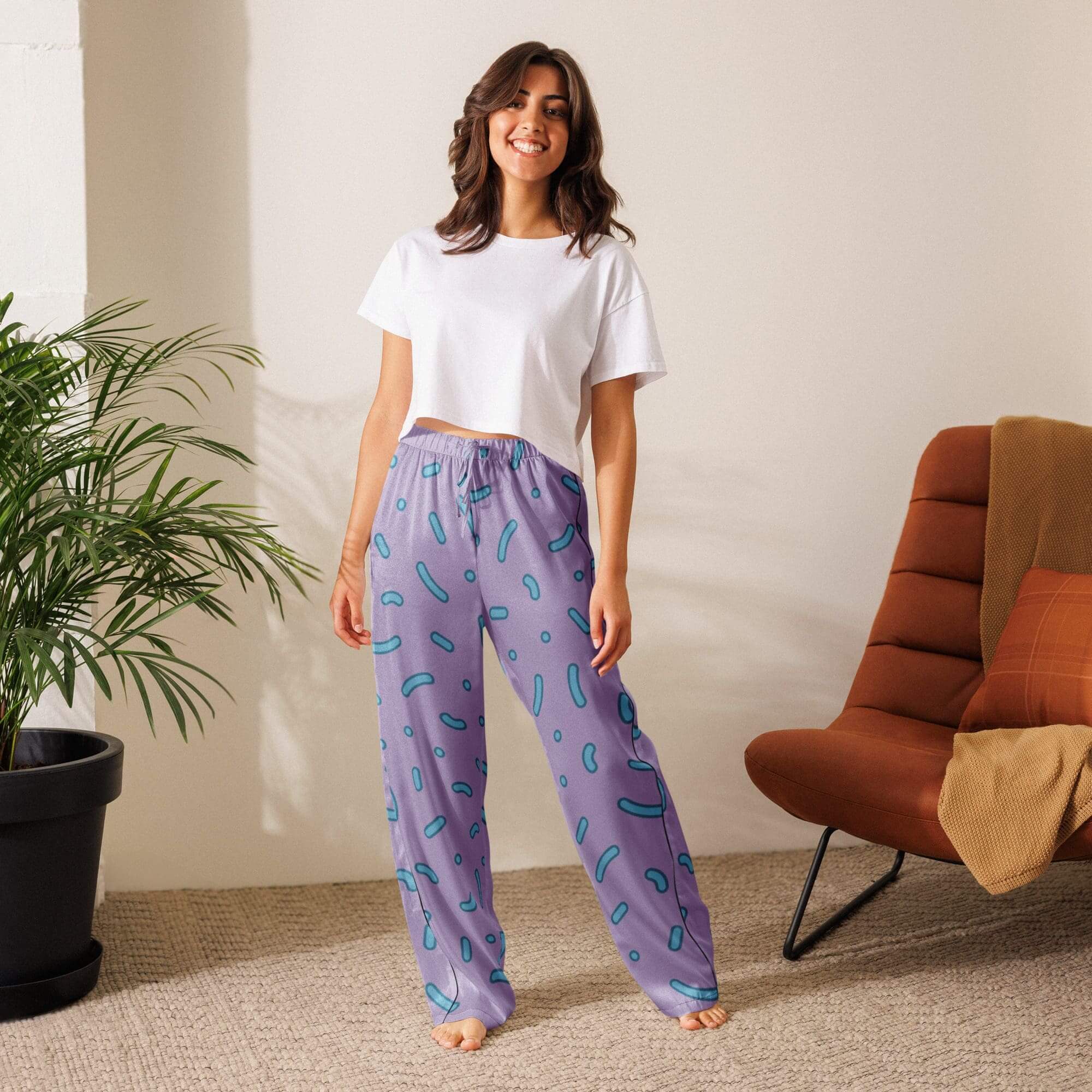 Woman in casual outfit standing indoors smiling.