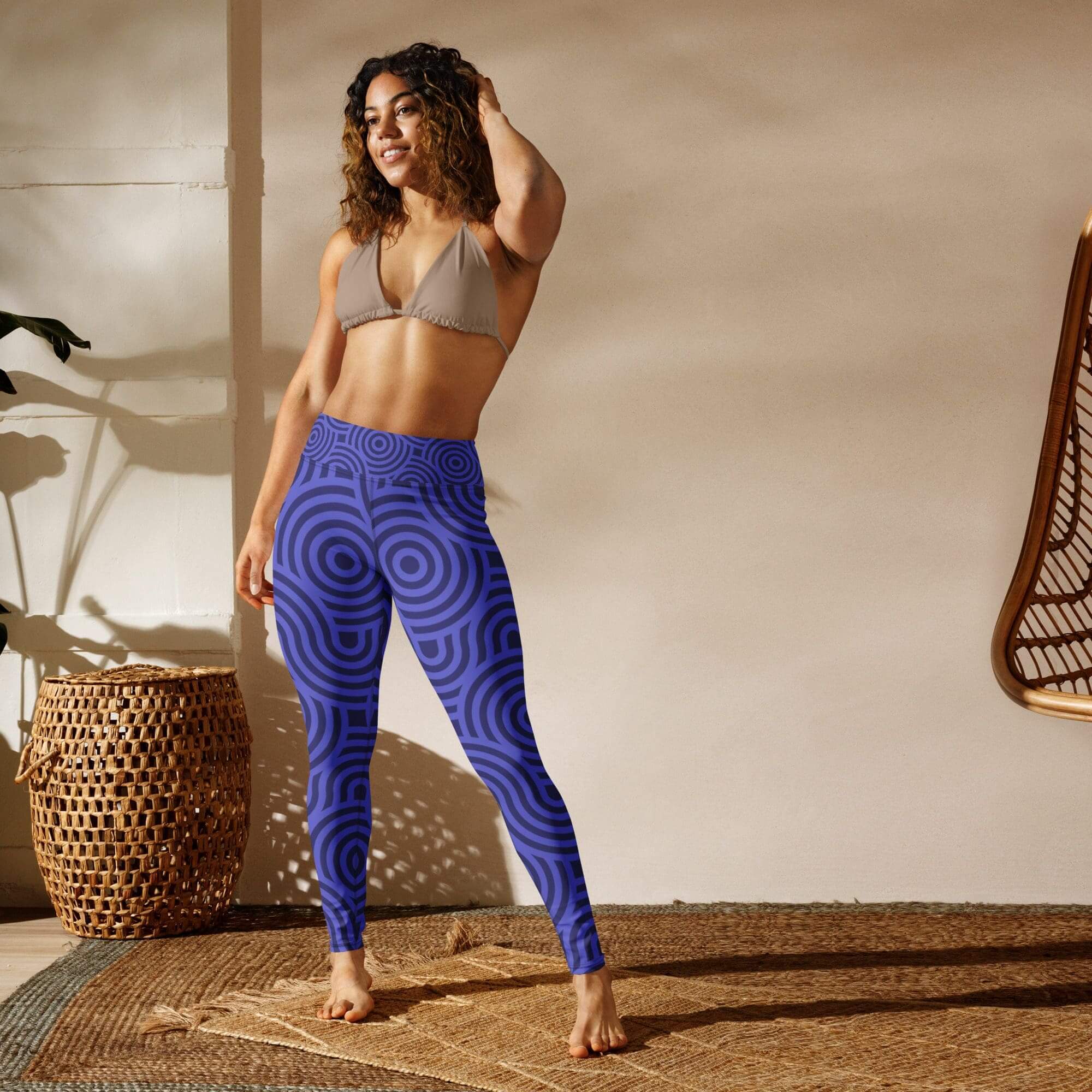 Woman posing in patterned leggings indoors.