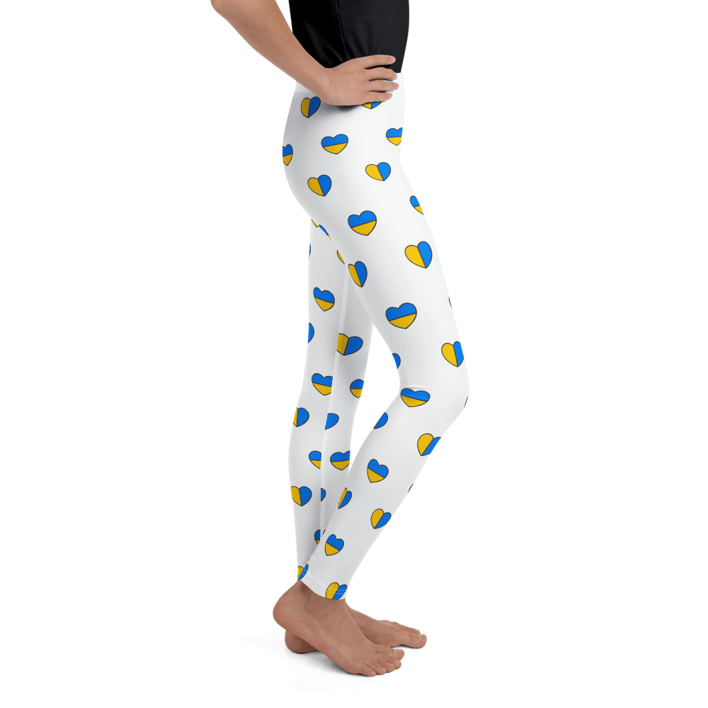 Person wearing white leggings with heart pattern.