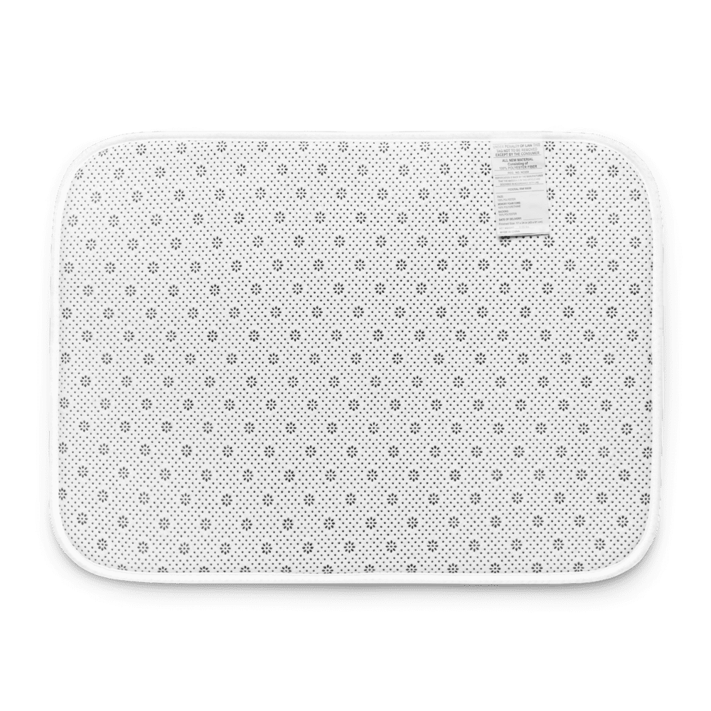 White bath mat with small floral pattern.