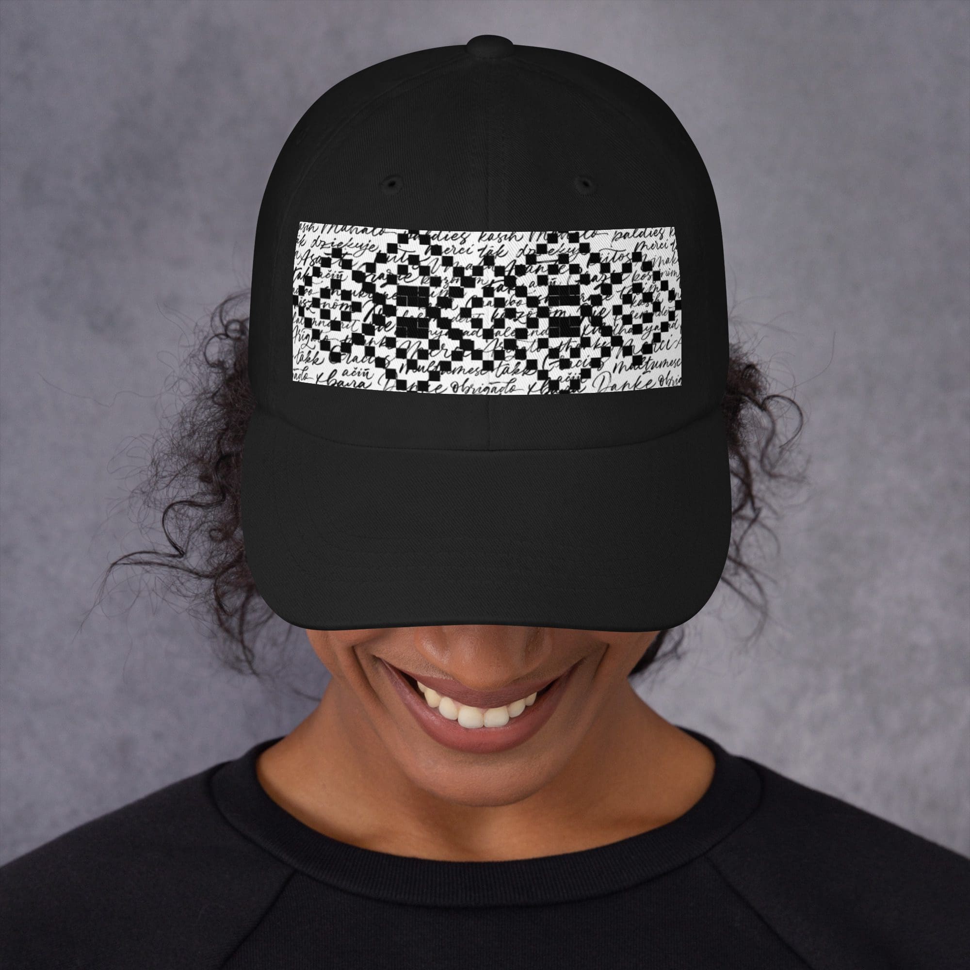 Person wearing black hat with geometric design.