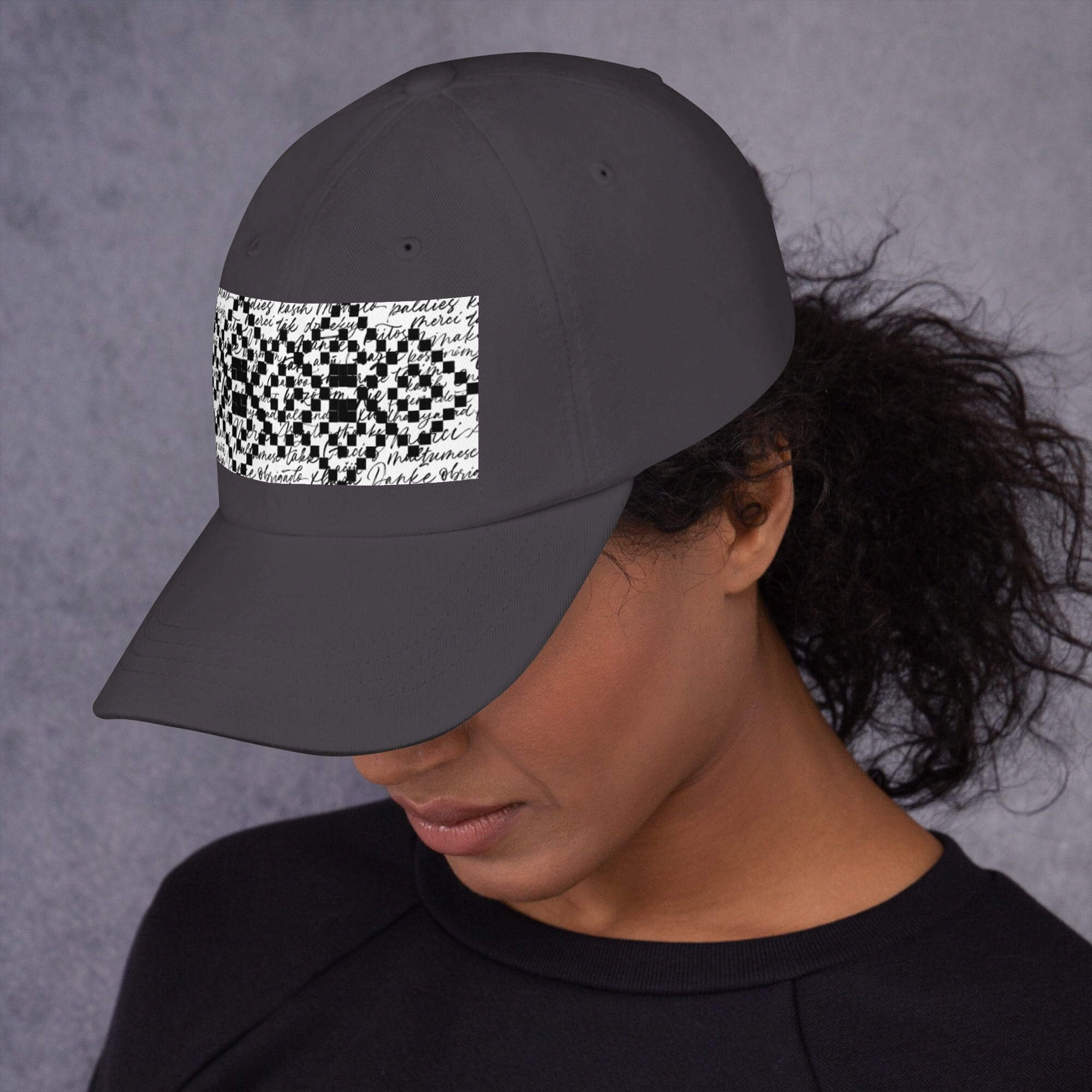 Woman wearing a black cap with design.