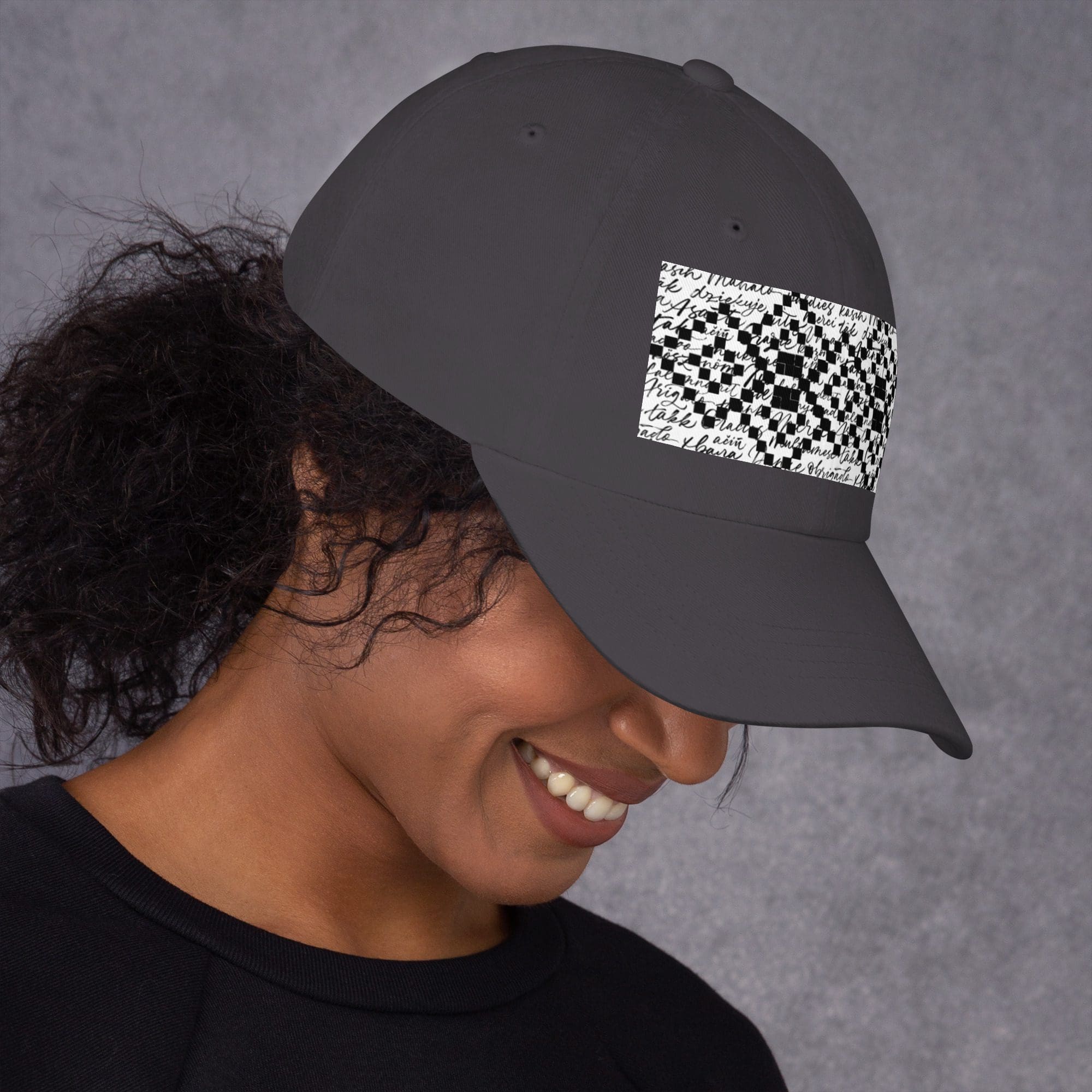 Smiling person wearing a dark patterned cap.