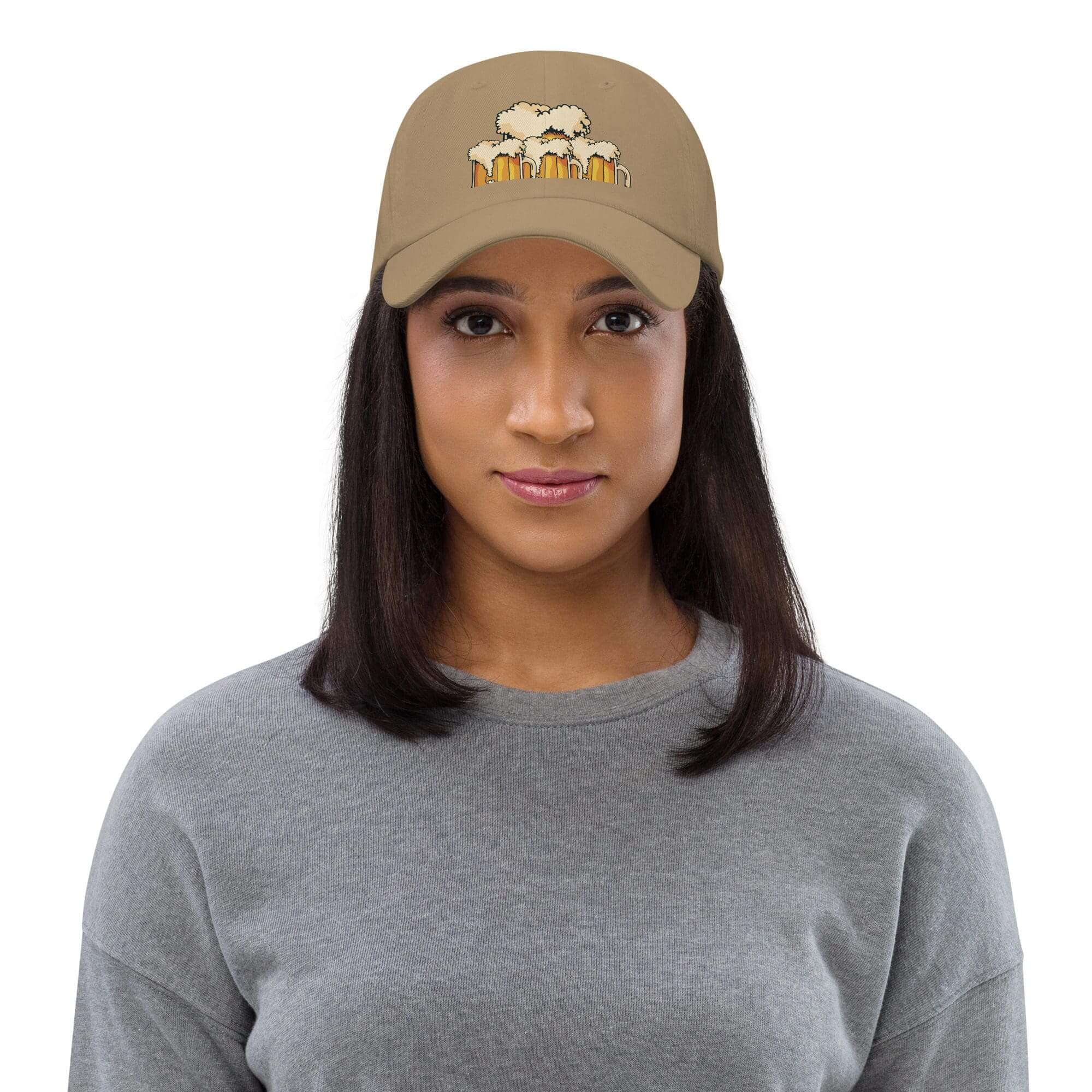 Woman wearing gray sweater and beige cap.