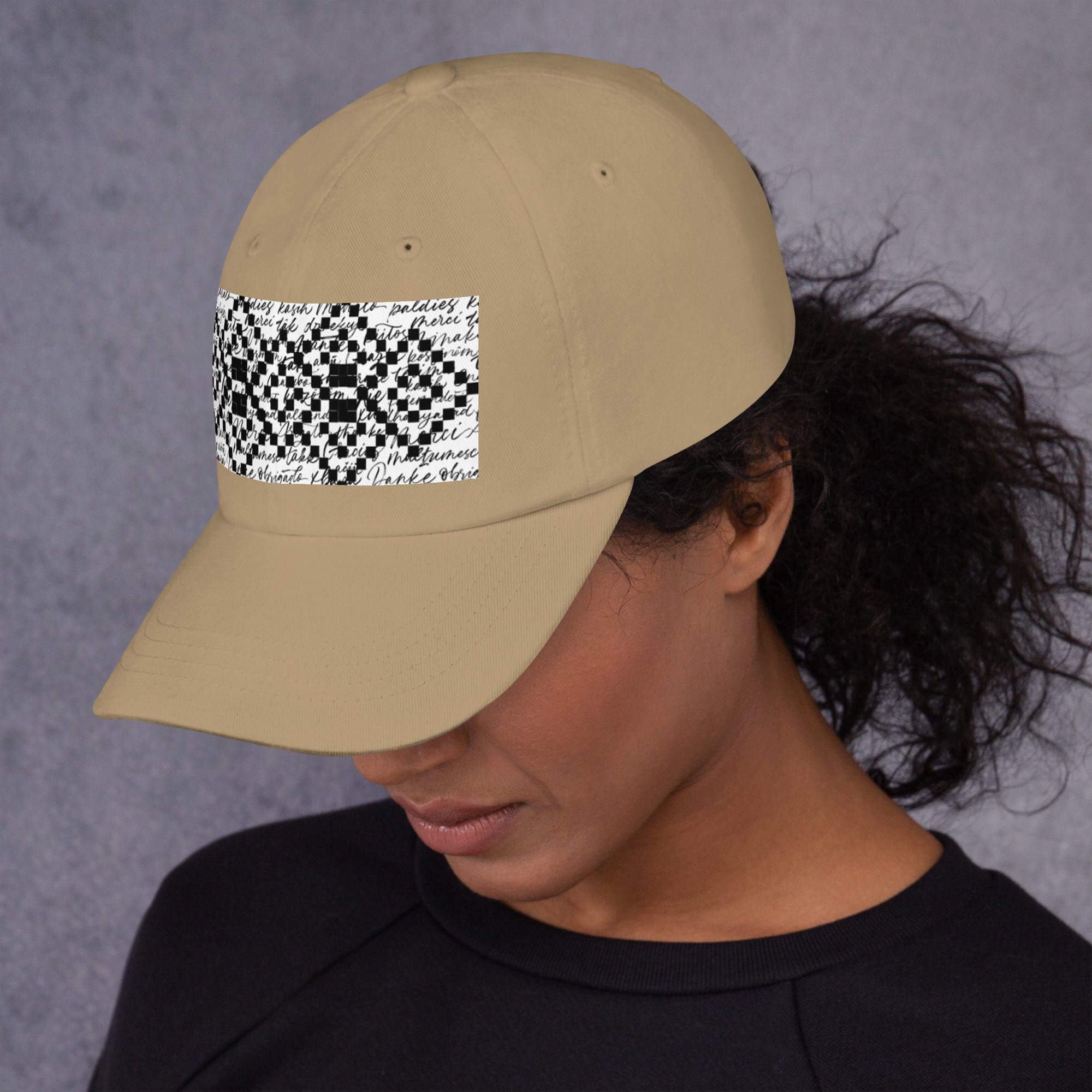 person wearing beige cap with checkerboard patch