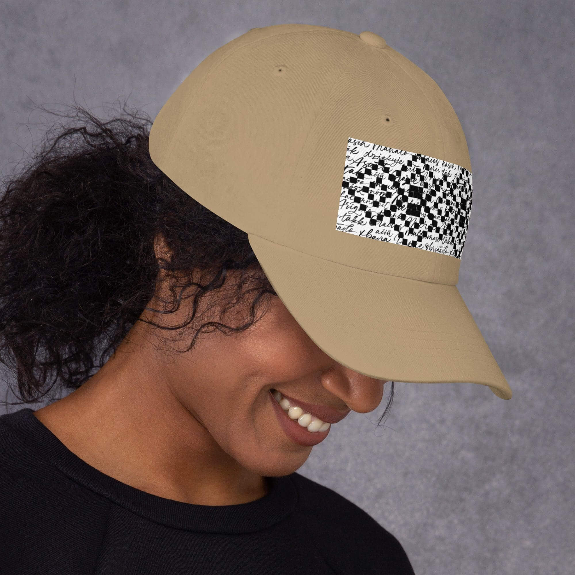 Smiling person wearing a beige patterned cap.
