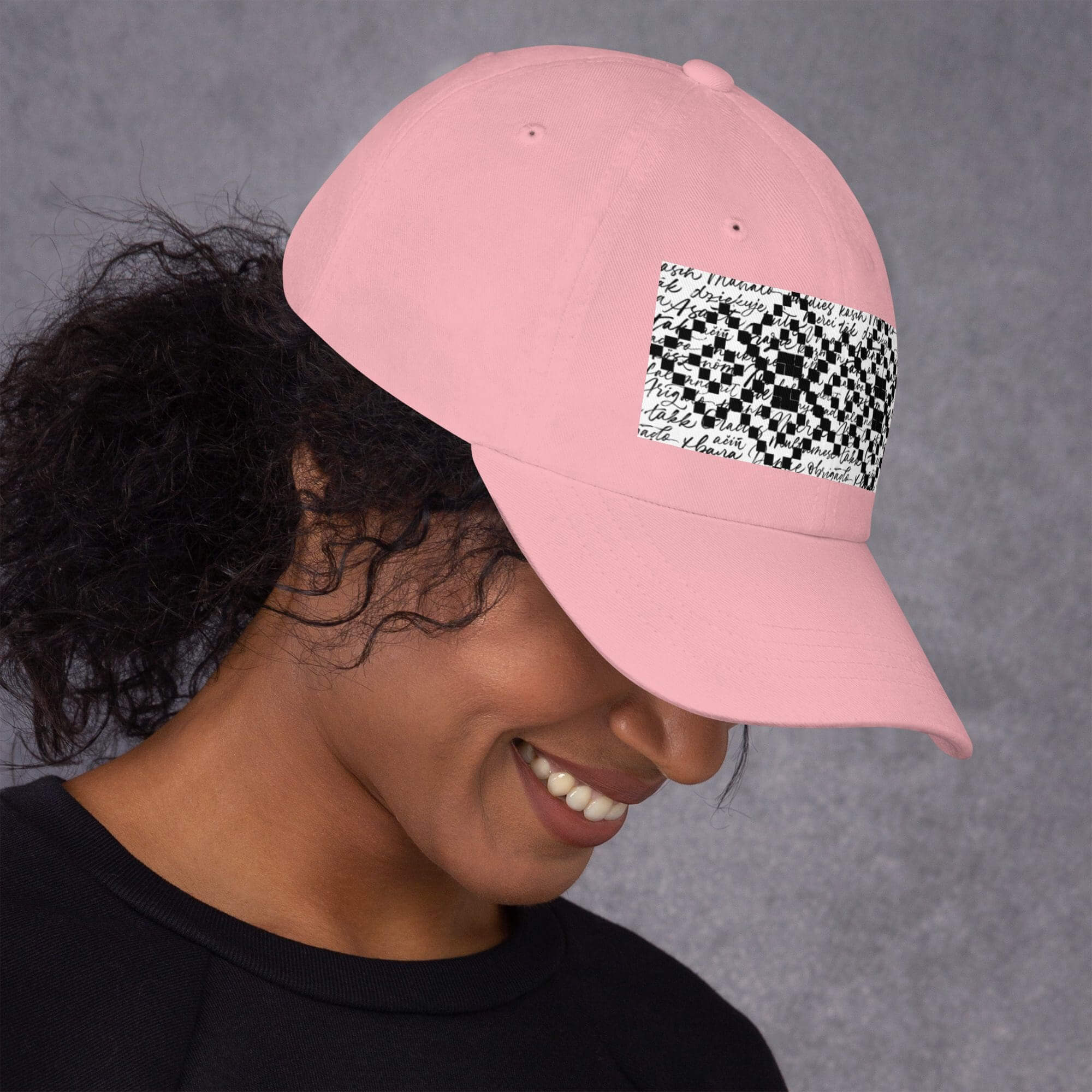 Person wearing pink hat with black design.