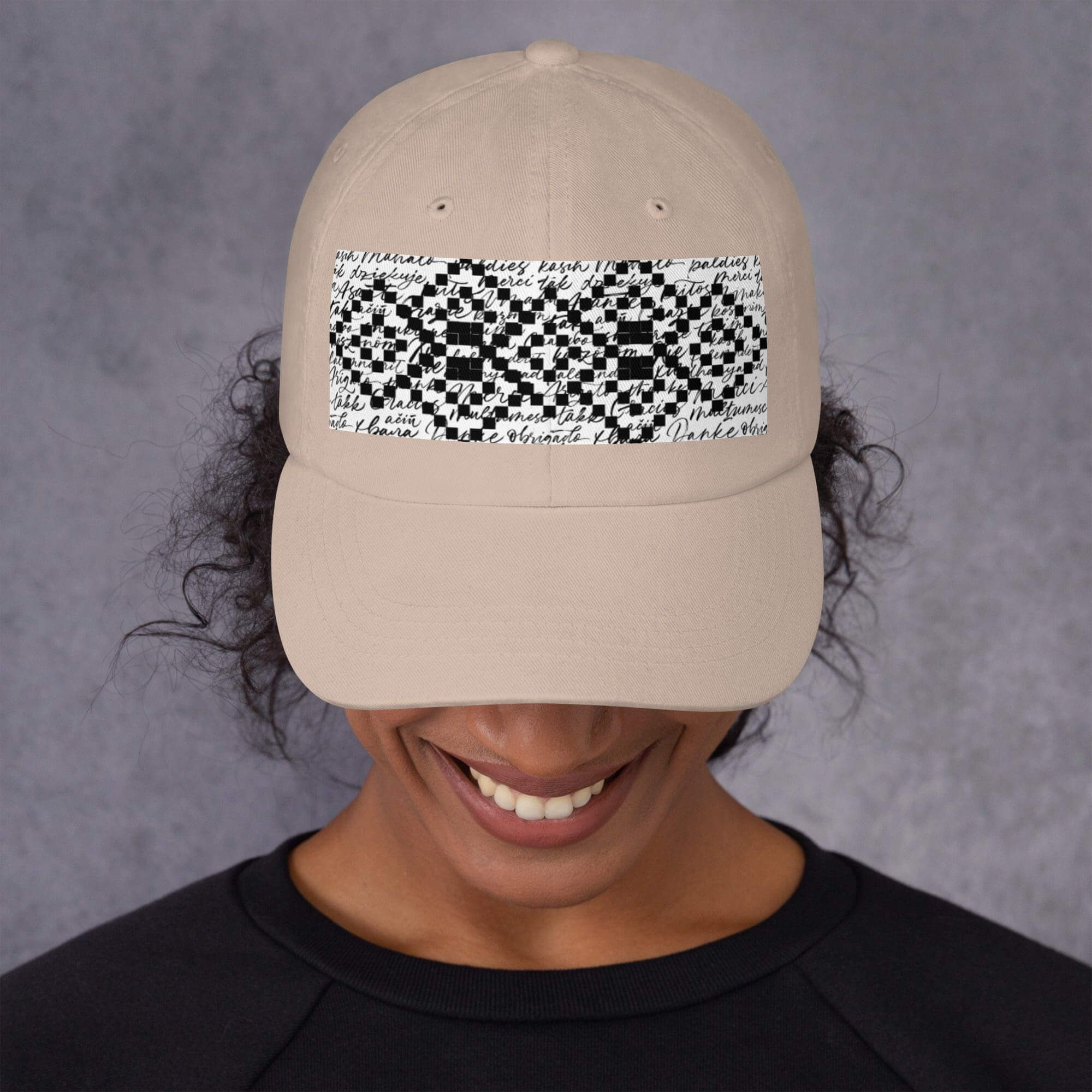 Person wearing beige cap with abstract design.
