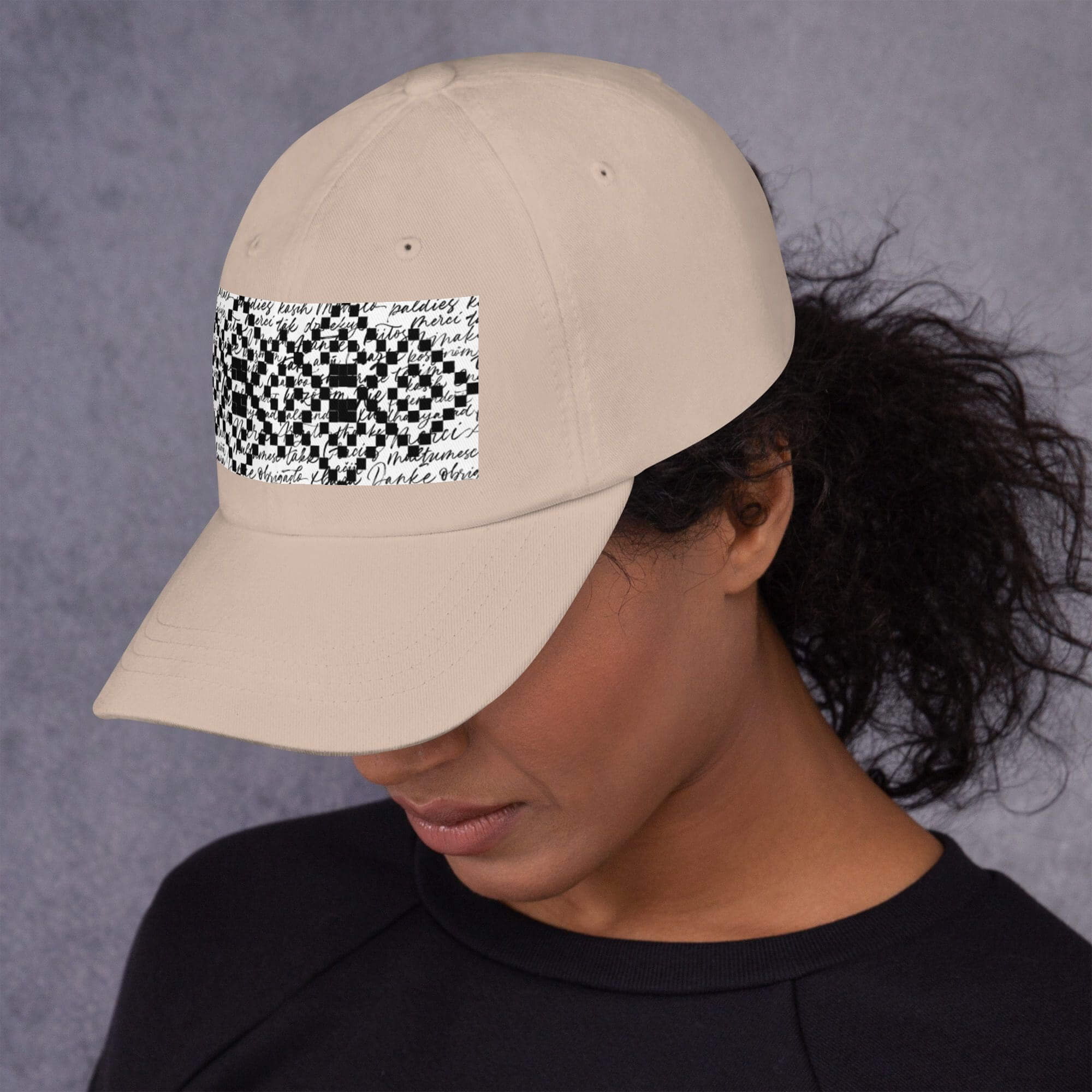 Woman wearing a beige cap, looking down.