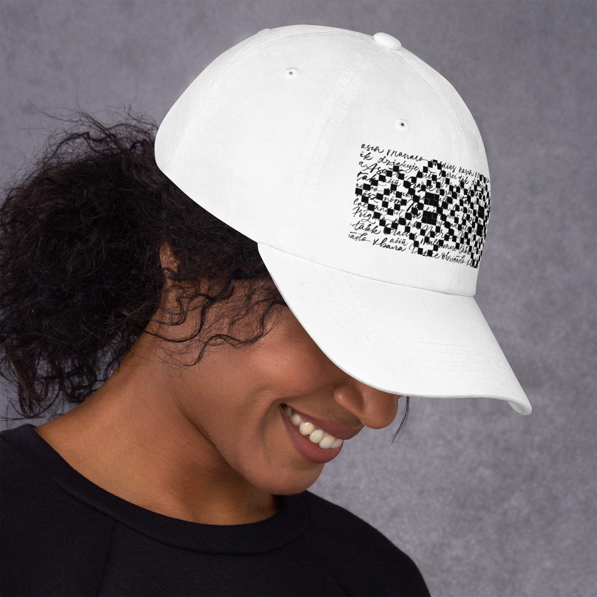 Woman wearing white hat with black pattern.