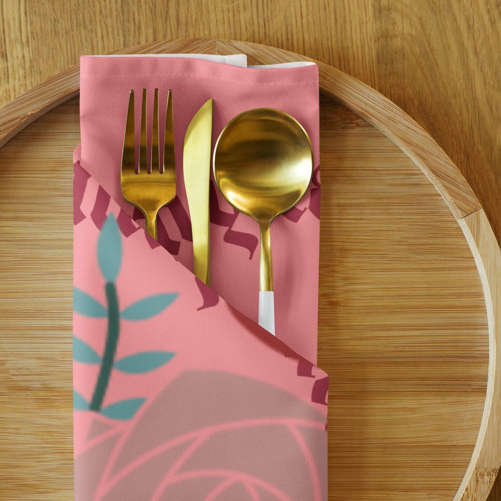 Gold cutlery on pink floral napkin.